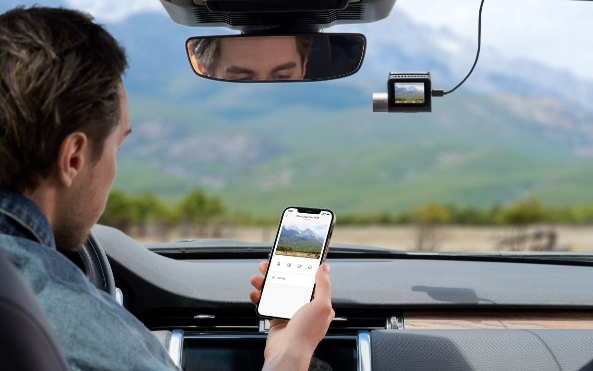 A man using the 70mai mobile app in his car