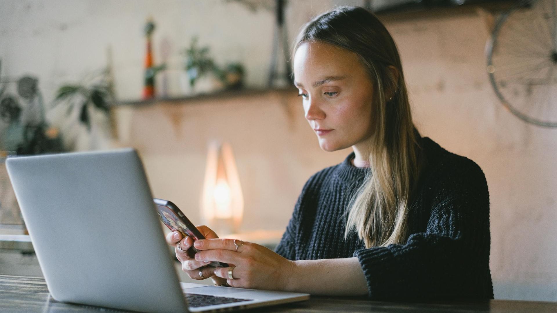 A person using a phone and a laptop