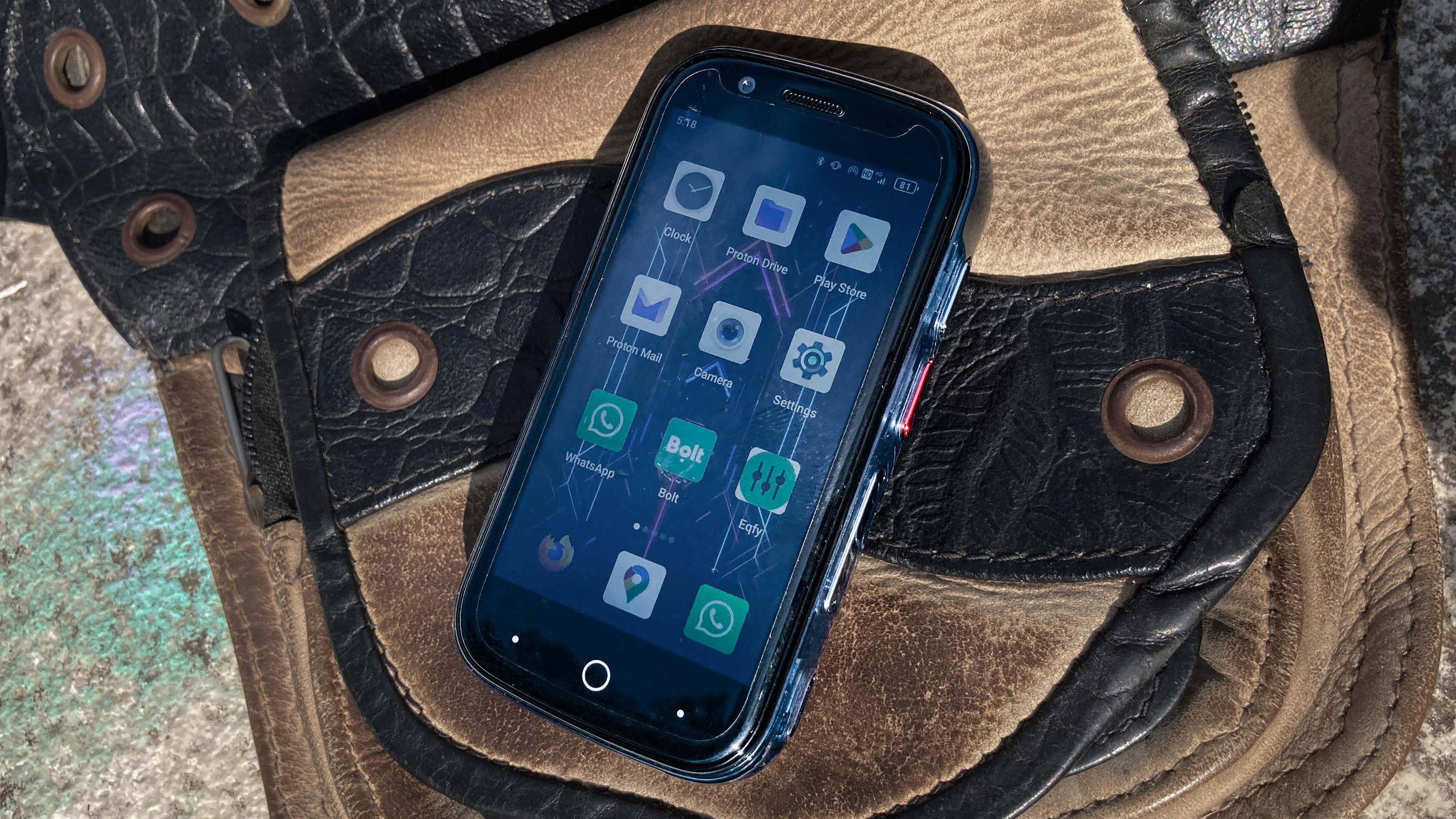 The Unihertz Jelly Star sitting on a leather pouch, displaying its home screen