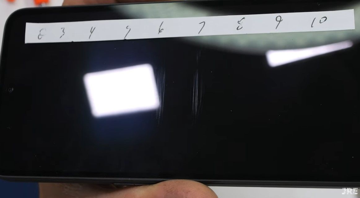 A CMF Phone 1 display with scratches on level 6 and 7 of the Mohs Hardness Scale.