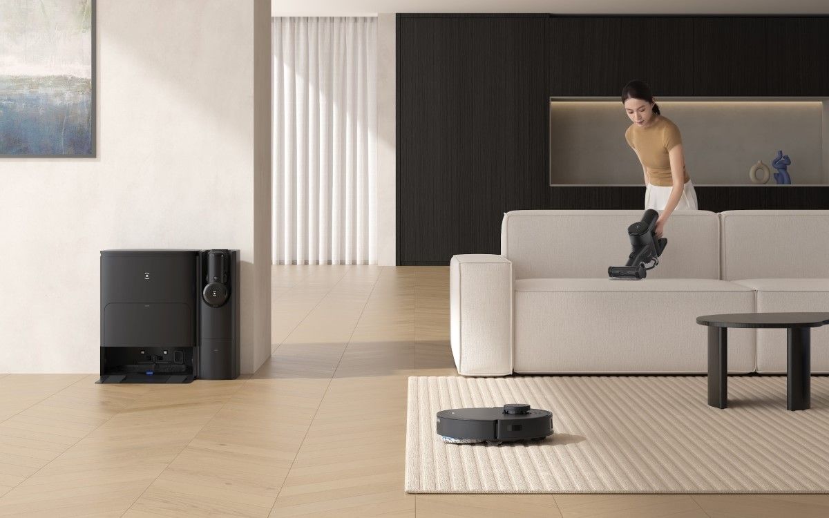 Deebot T30S cleaning a carpet while a woman uses the handheld vacuum