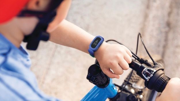 Kid looking at Fitbit Ace 3 on bike