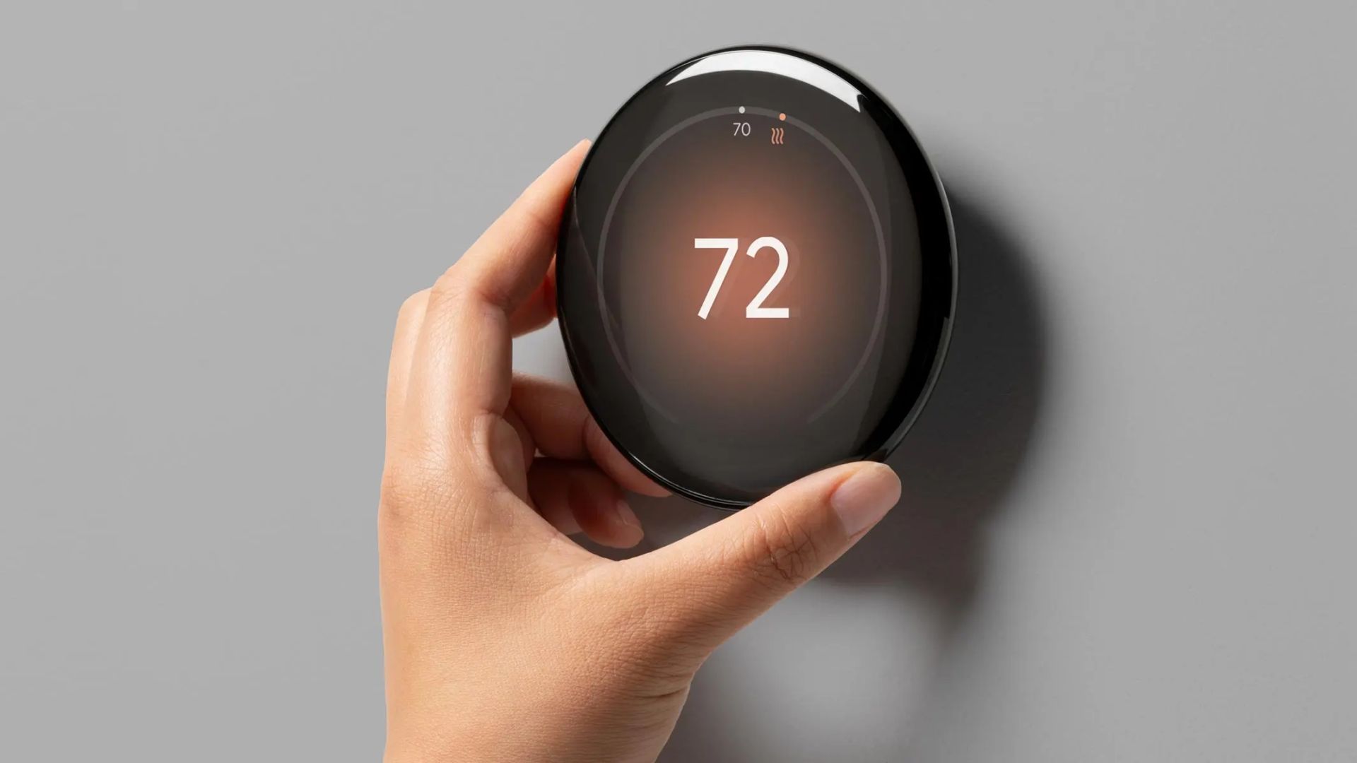 Hand turning the dial on Google Nest Learning Thermostat