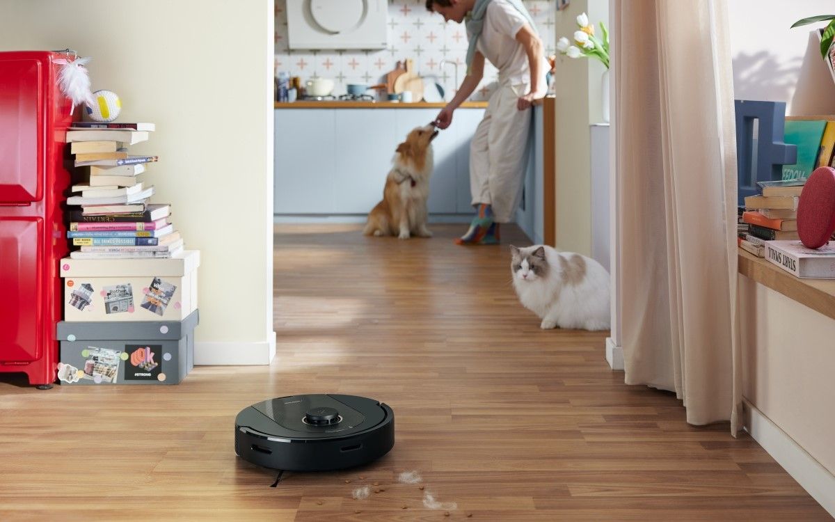 Q5 Pro+ cleaning pet hair while a man feeds his pet dog and cat