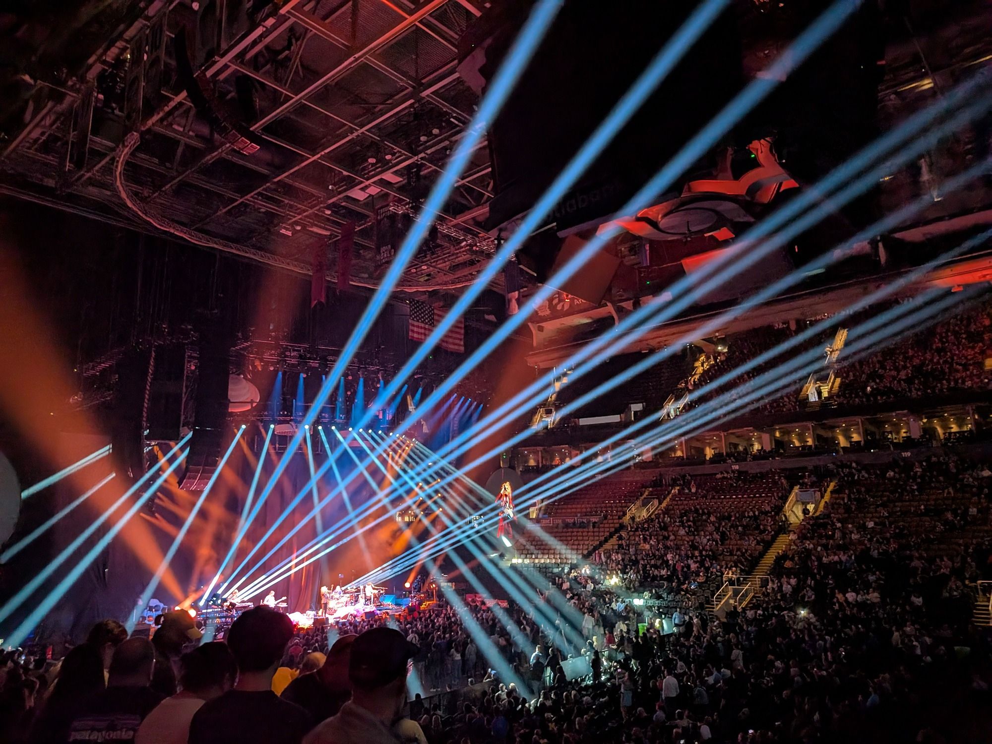 Una foto de un concierto con vigas de luz emitiendo desde el escenario
