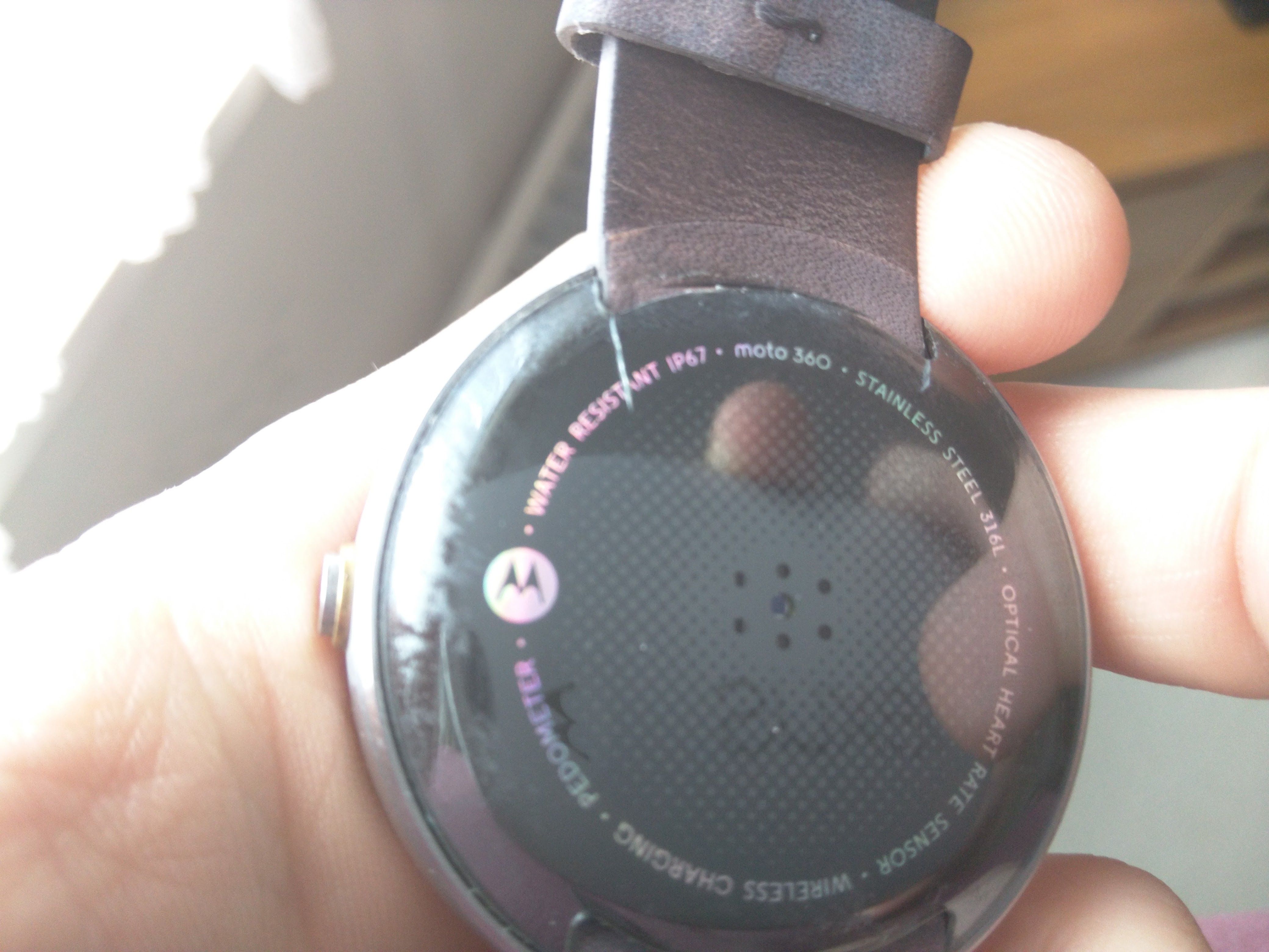 A photo of the 2014 Moto 360 with a cracked back