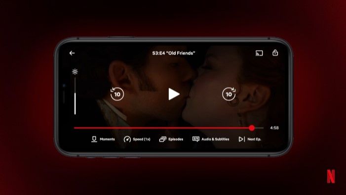 Screenshot of Netflix video on iPhone. The actor and actress are kissing and at the bottom[モーメント]Tabs are displayed.