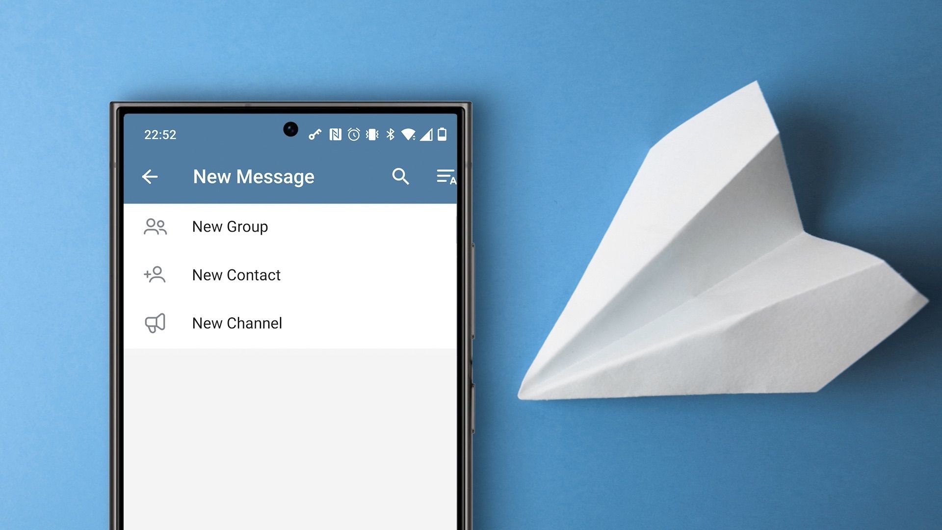 Smartphone beside paper plane with Telegram group creation options on the display