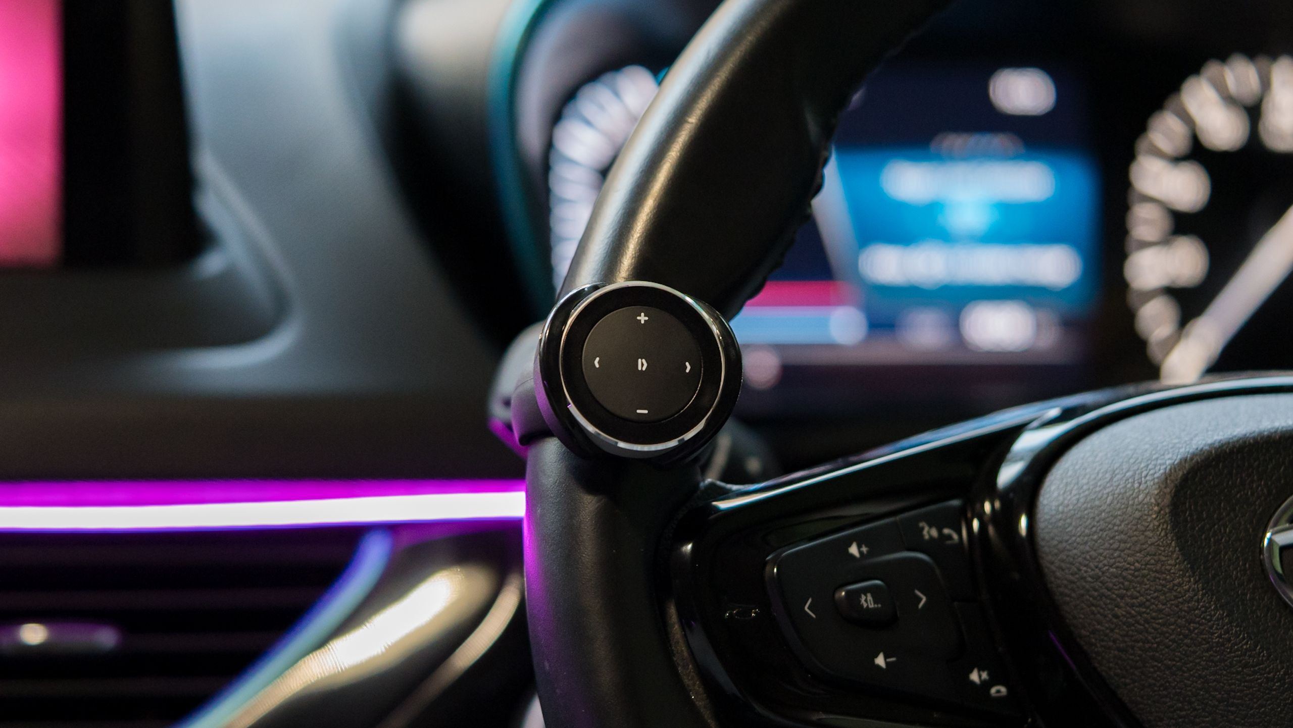 A Satechi Media Button attached to a car steering wheel