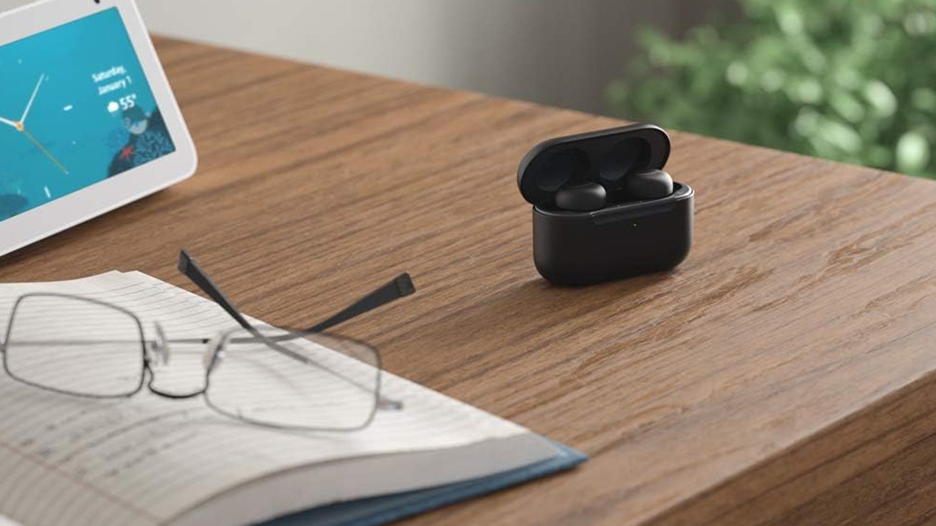 The Amazon Echo Buds in their charging case on a desk.