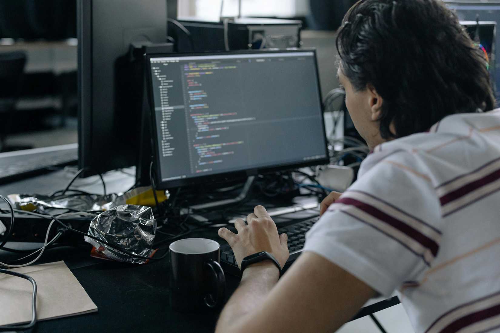 A developer sitting in front of a computer that has code on the screen