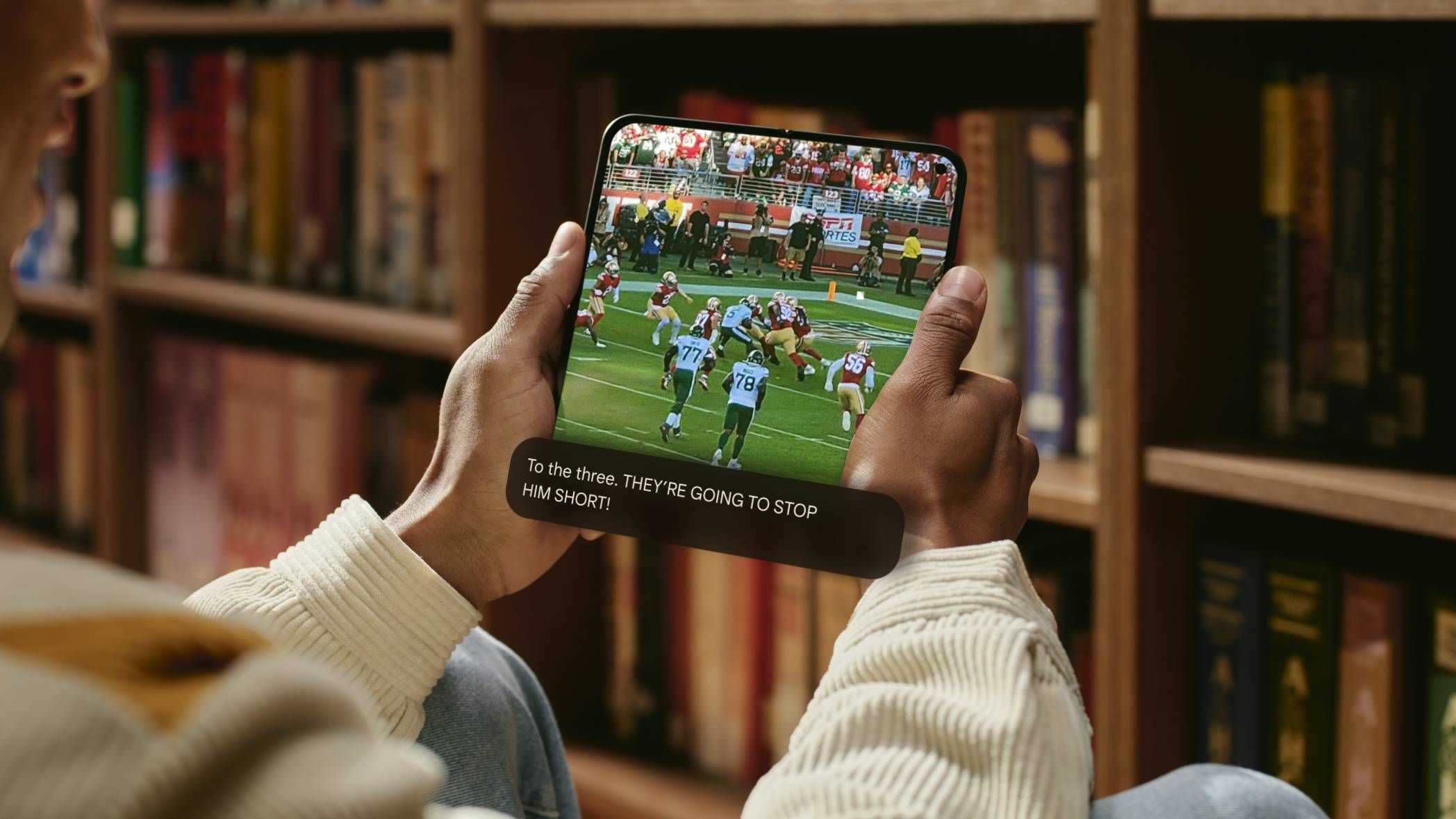 A person holding the Pixel 9 Pro Fold with expressive captions enabled.