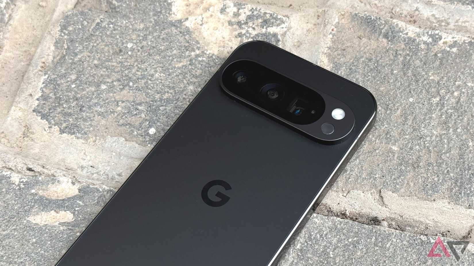 A Google Pixel 9 Pro ، مع شريط الكاميرا البارز ، يستريح Facedown على الحجارة