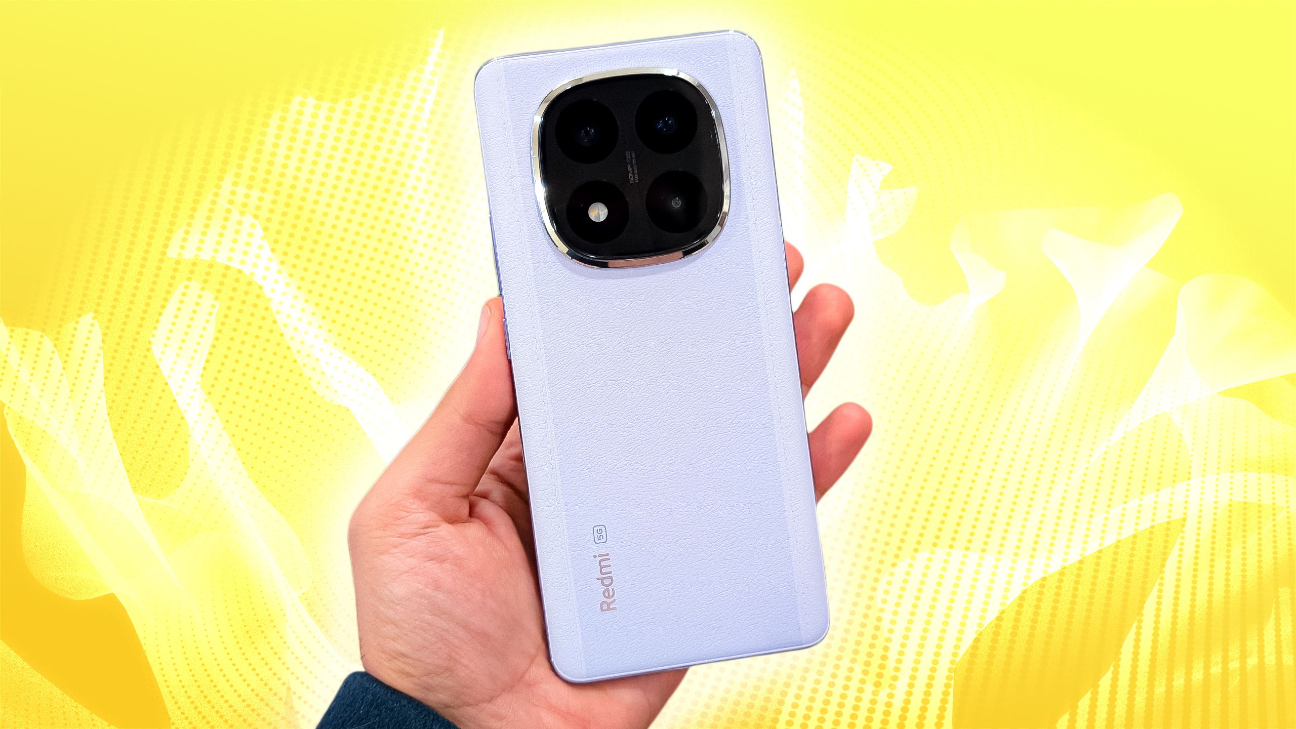 A Xiaomi Redmi Note 14 Pro+ mid-range phone held in a hand against a yellow background