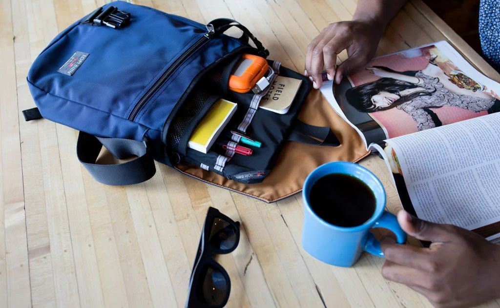 Blue Tom Bihn Medium Cafe Bag full of tech gadgets sitting on a table