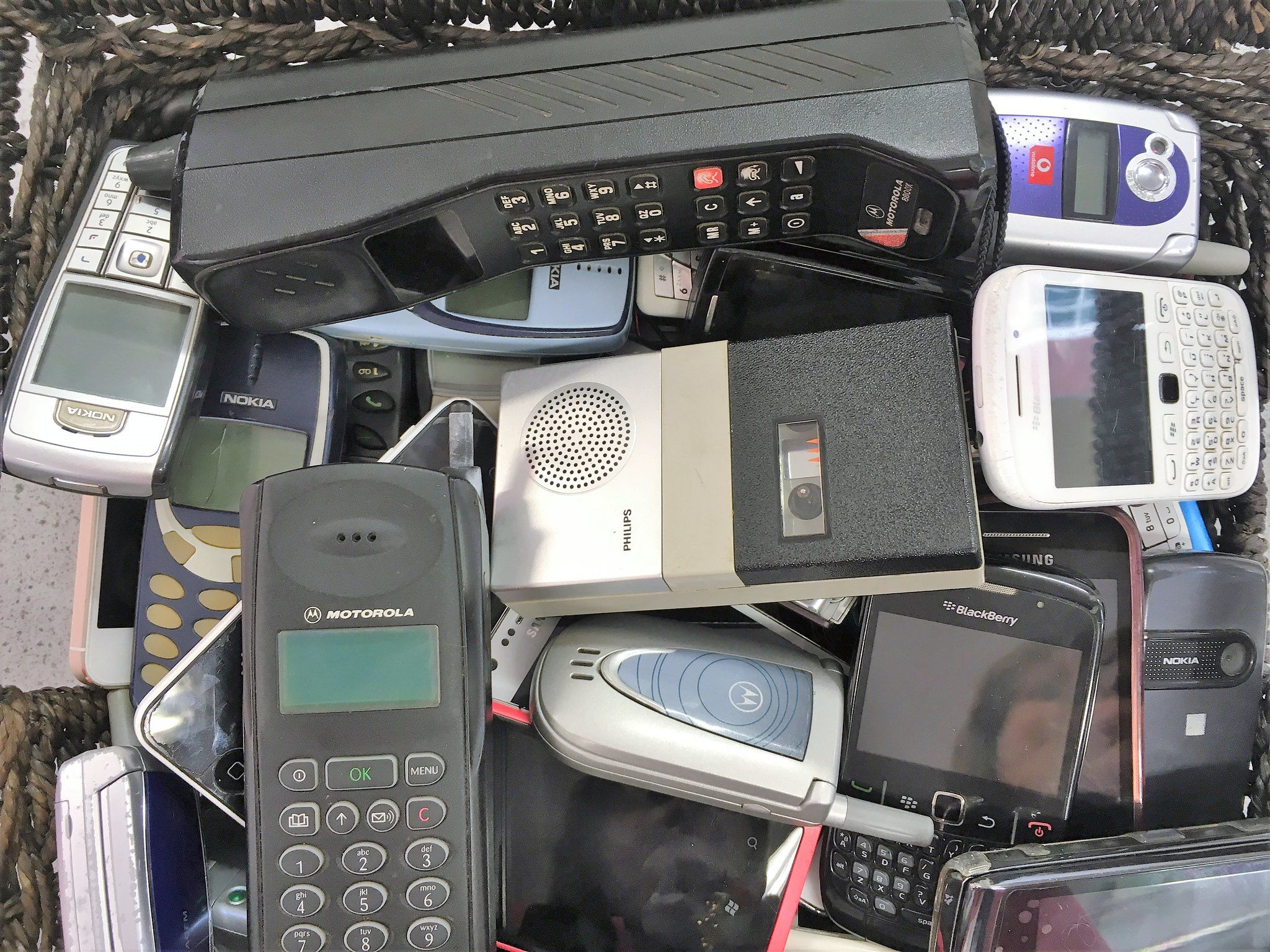 Dozens of old phones in a wicker basket 