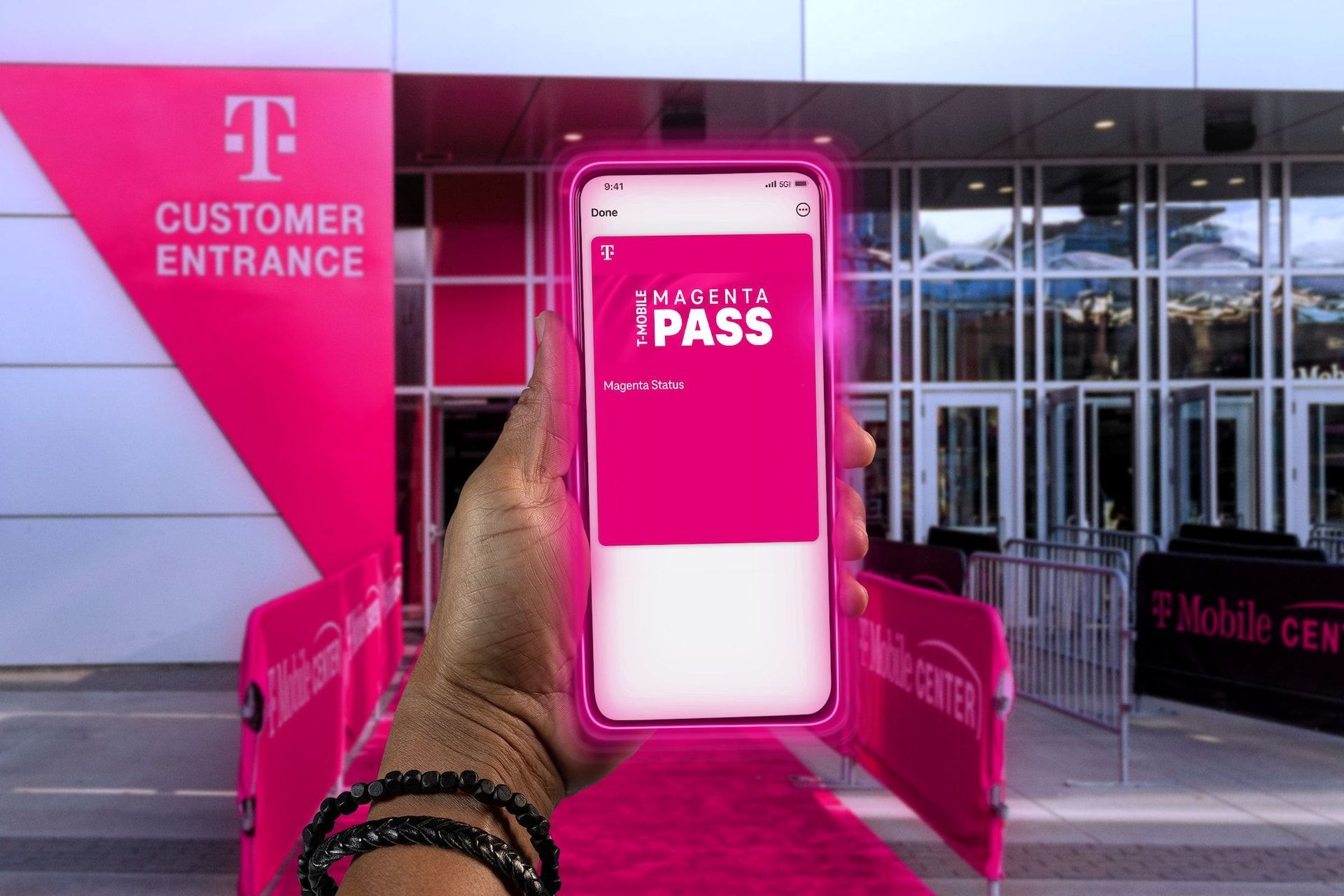 A person holding phone with the T-Mobile Magenta pass visible on the screen