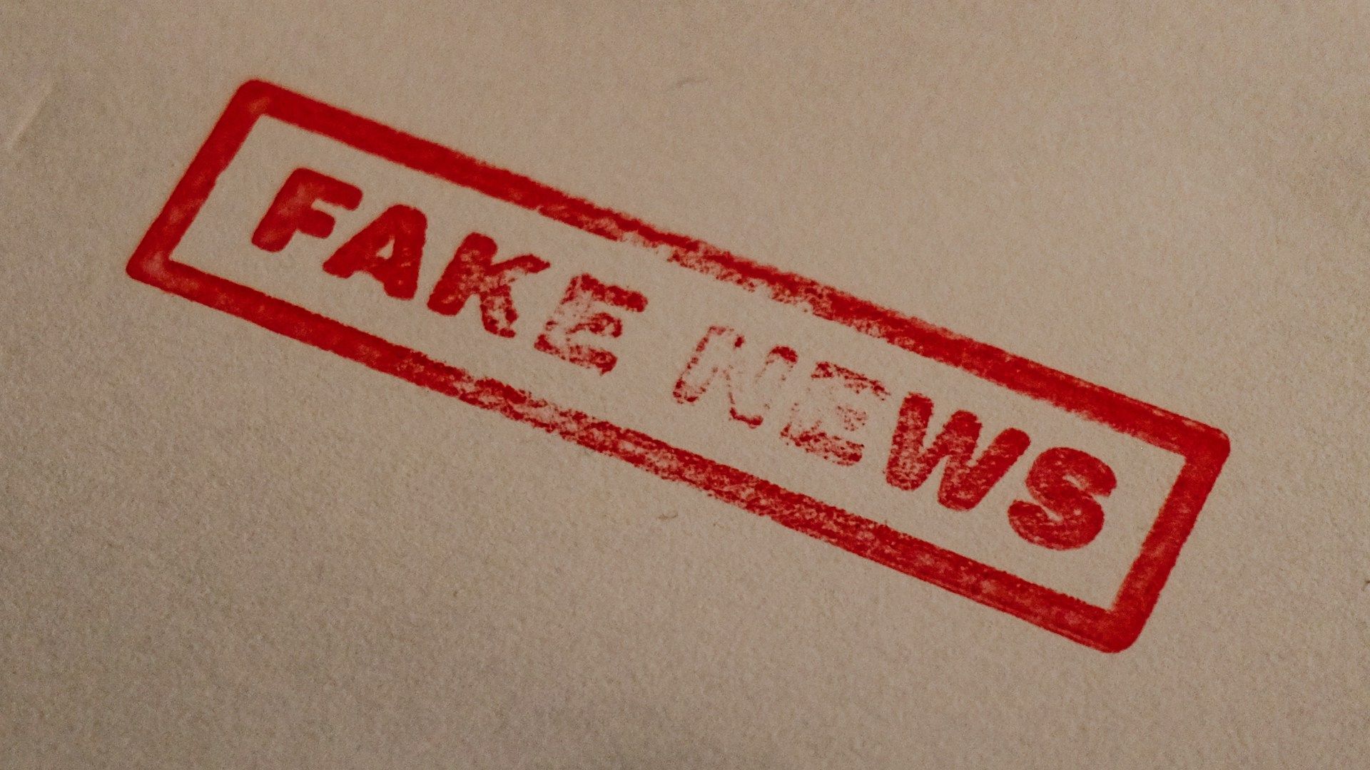 A sheet of paper stamped with 'Fake News' in red ink