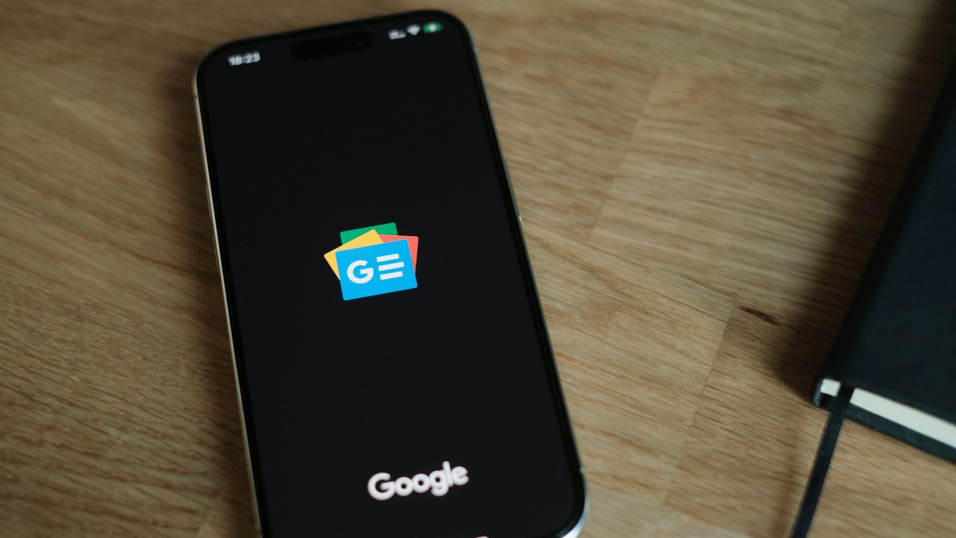A smartphone with the Google News app icon on the screen