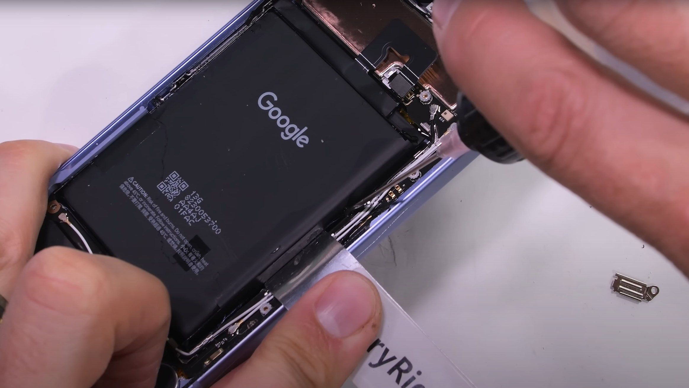 A screenshot of the JerryRigEverything YouTube channel trying to remove the Pixel 9a's battery.