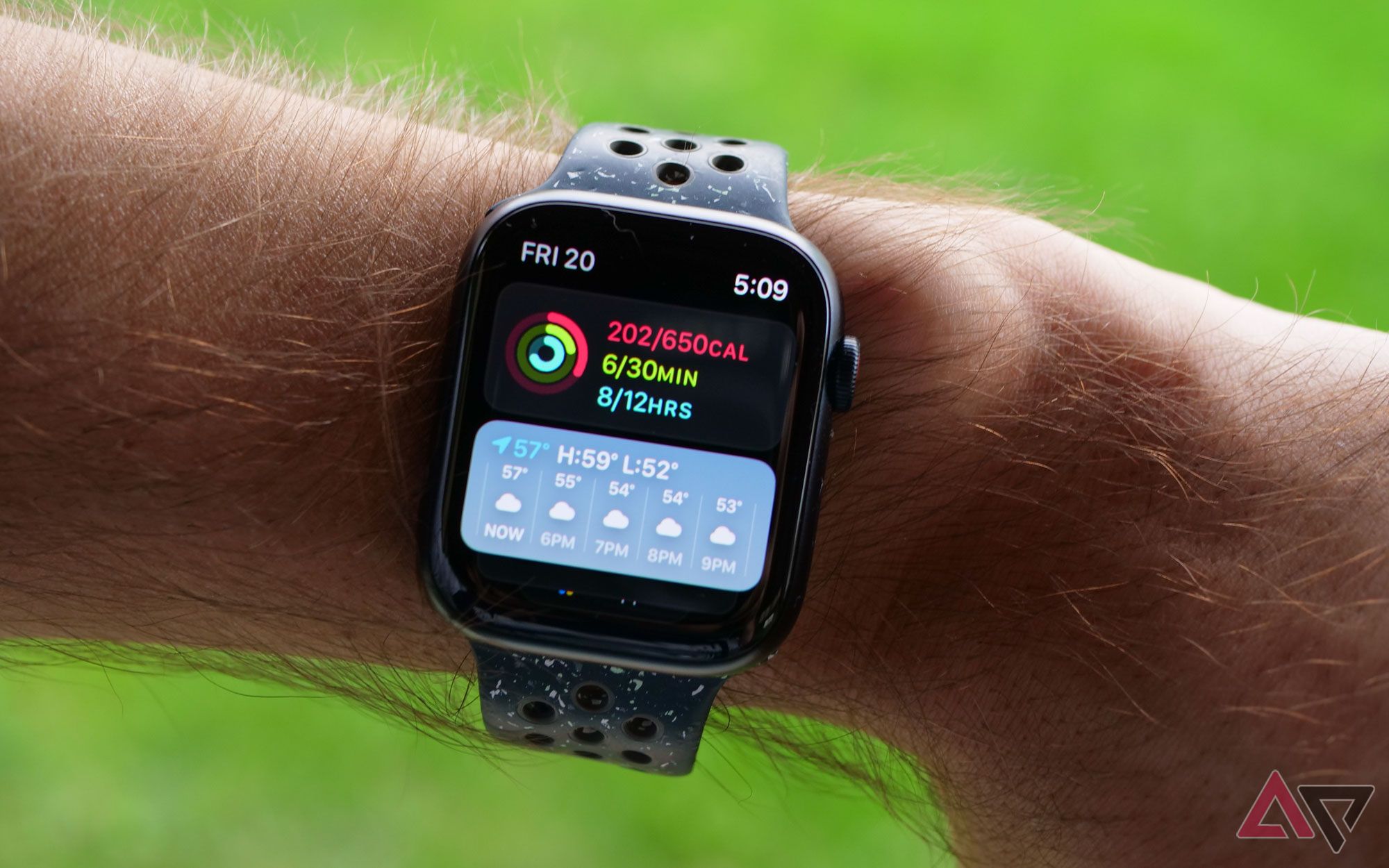An Apple Watch on a wrist displaying fitness and weather information