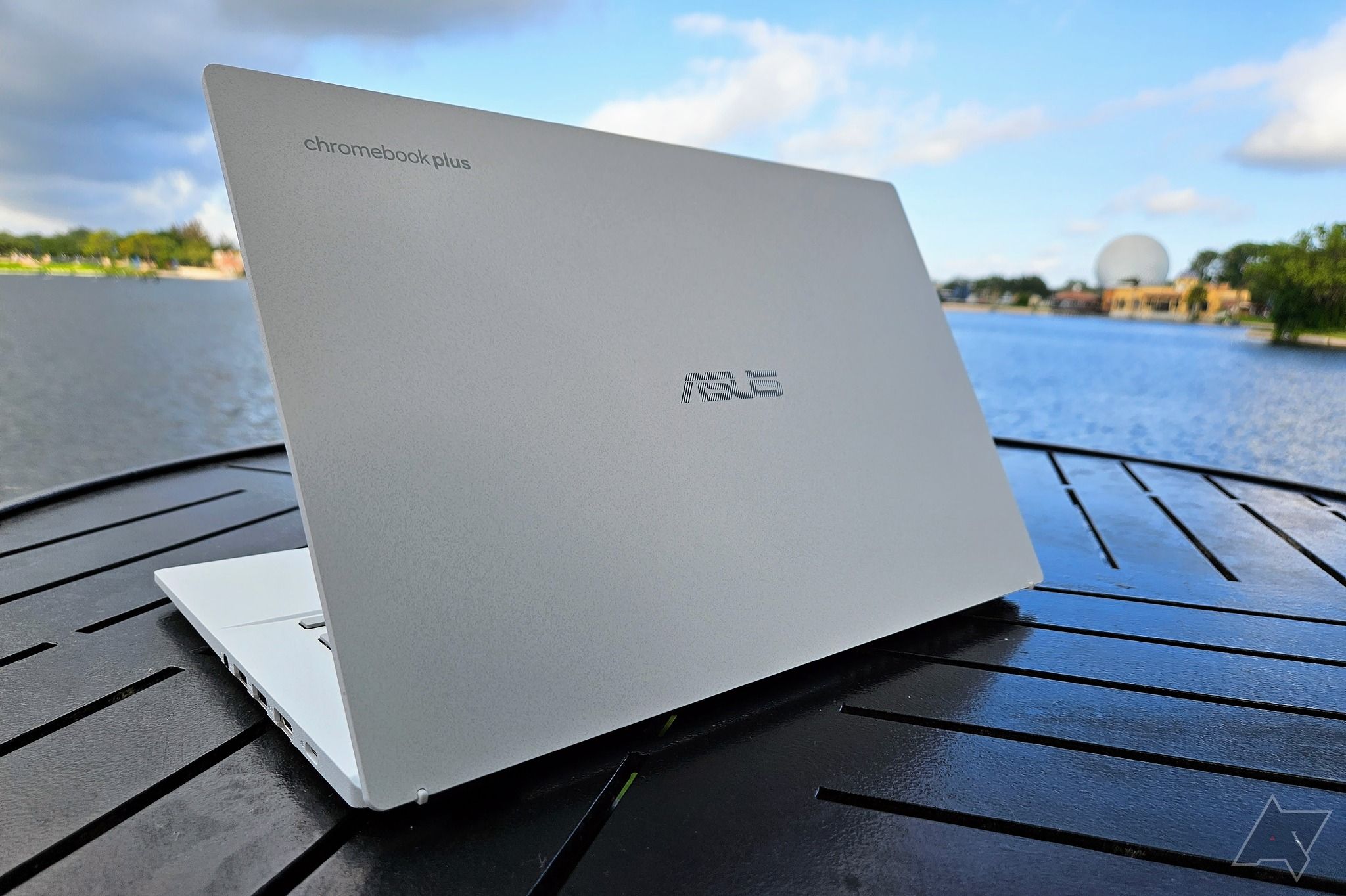 Asus Chromebook Plus CX34 sitting on a bench near the beach.