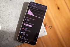 A Pixel 8 with battery app open resting on edge of grey table