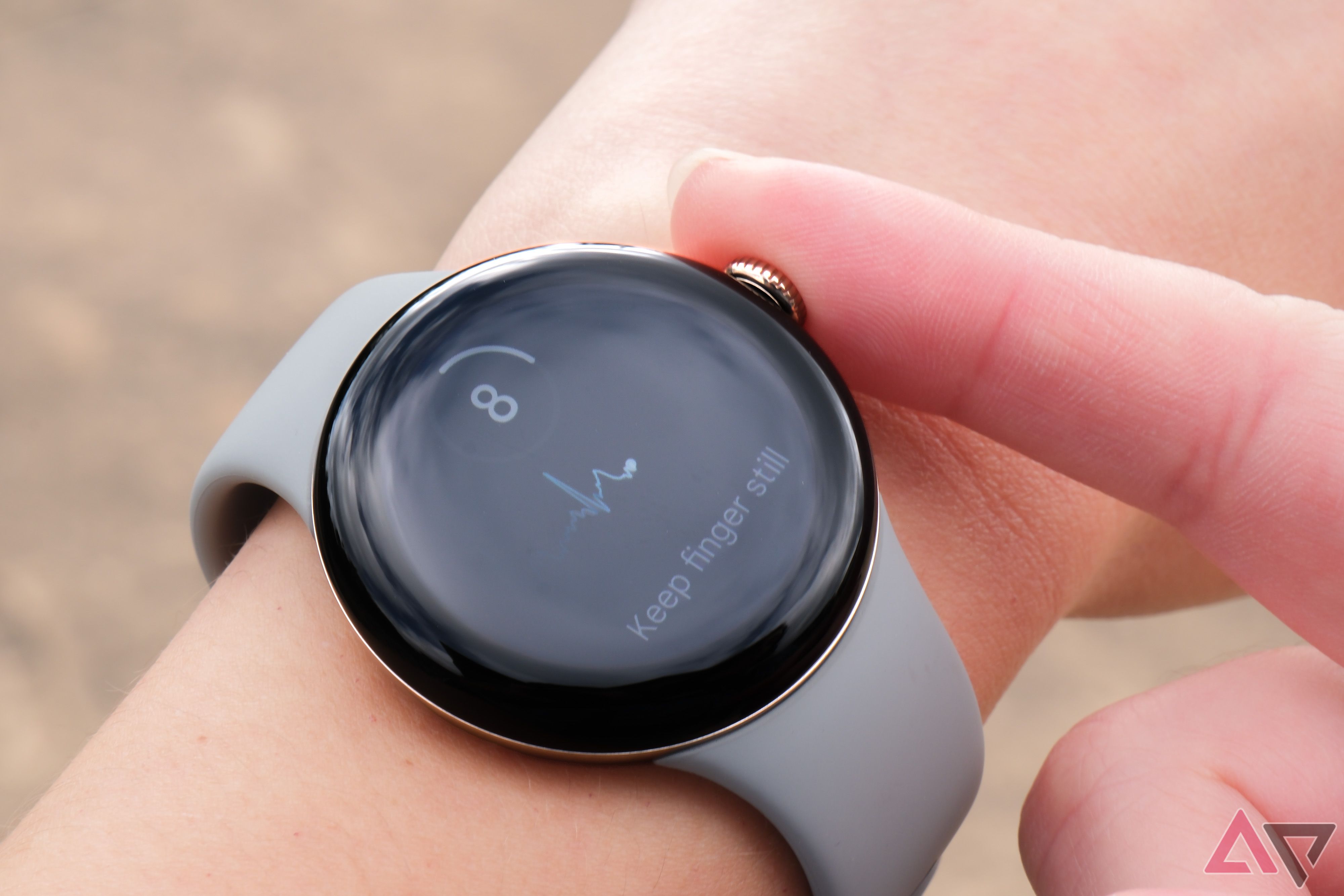 A person adjusts the knob on the side of a grey Pixel Watch 2.