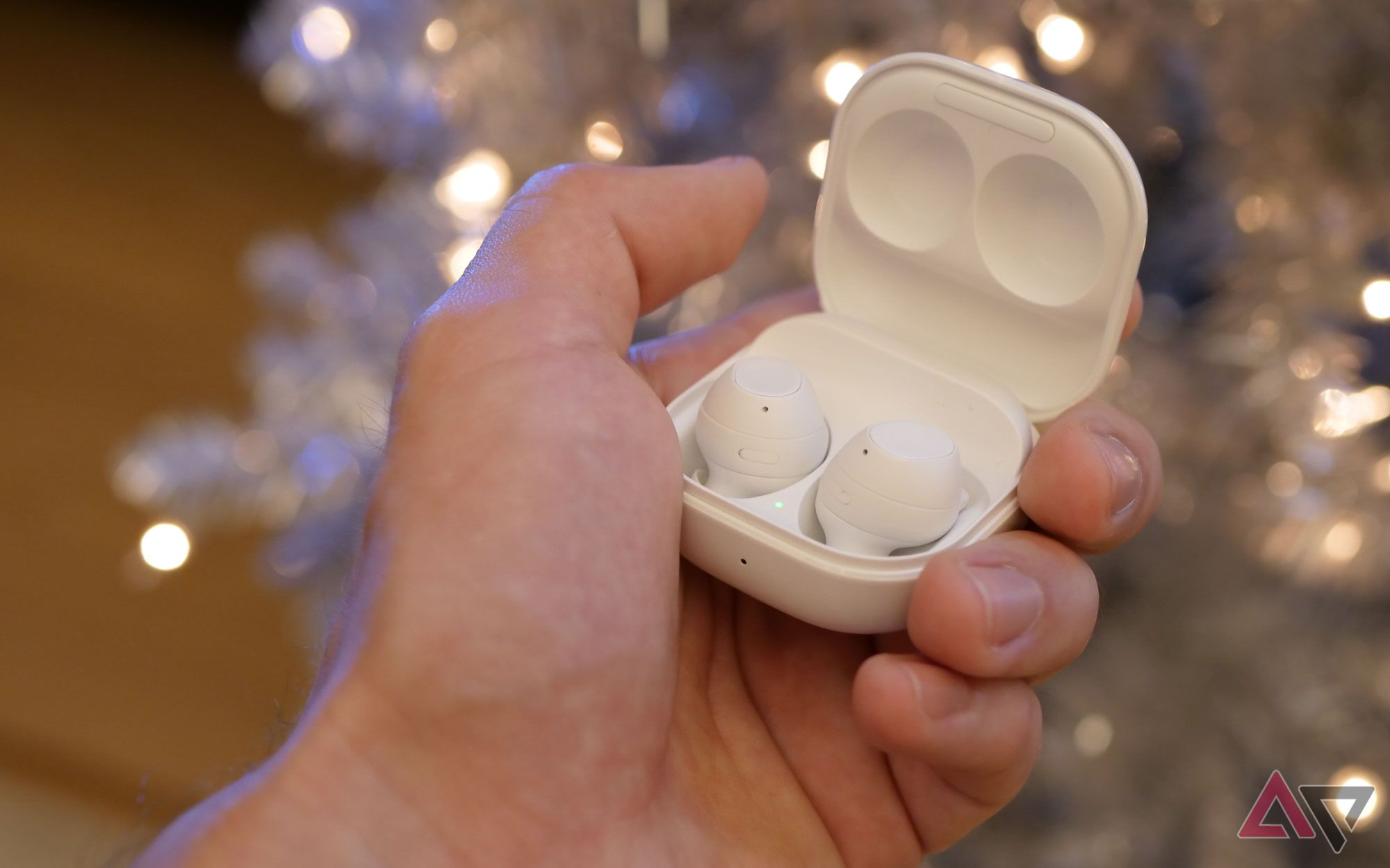 White Samsung Galaxy Buds FE in the hands of a user