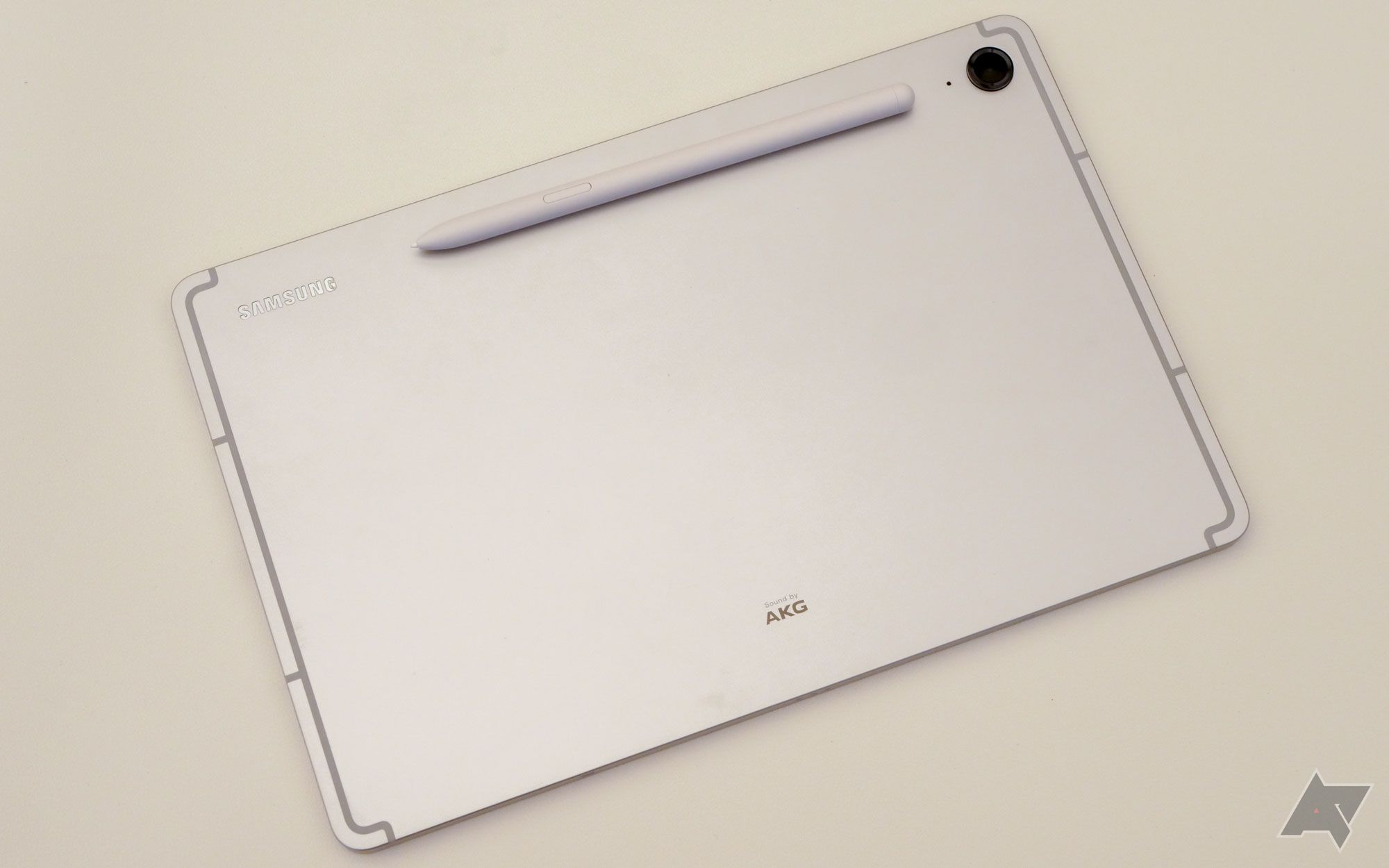 Samsung Galaxy Tab on a white surface with compatible S pen laying on top