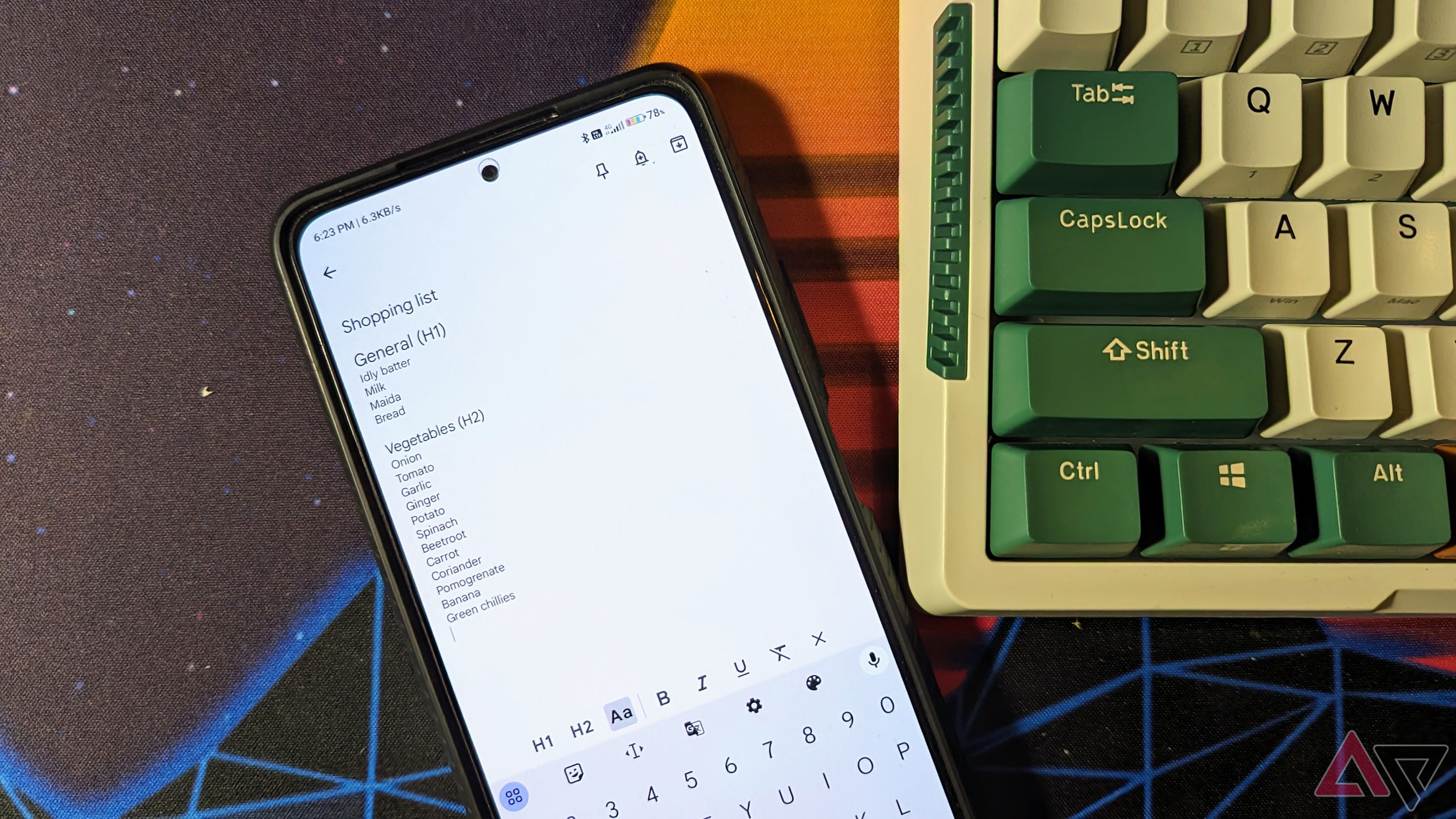 A phone displaying the Google Keep notes app sits next to a keyboard
