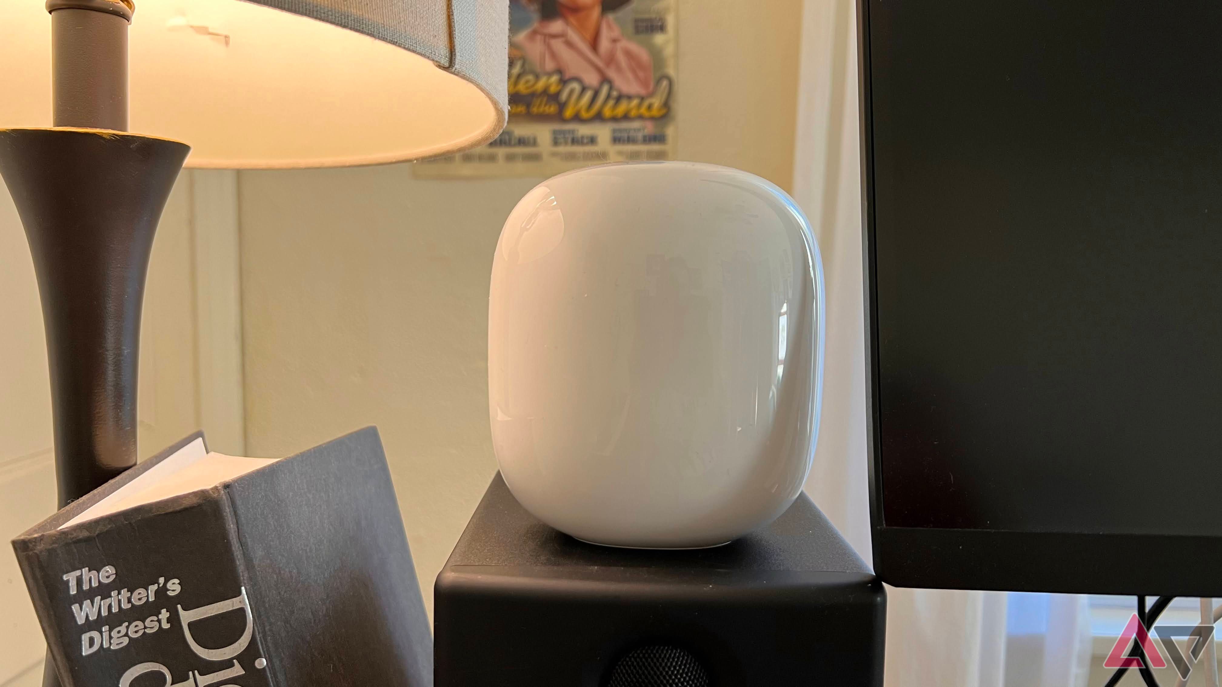 Google Nest Wifi Pro siting on speaker next to monitor