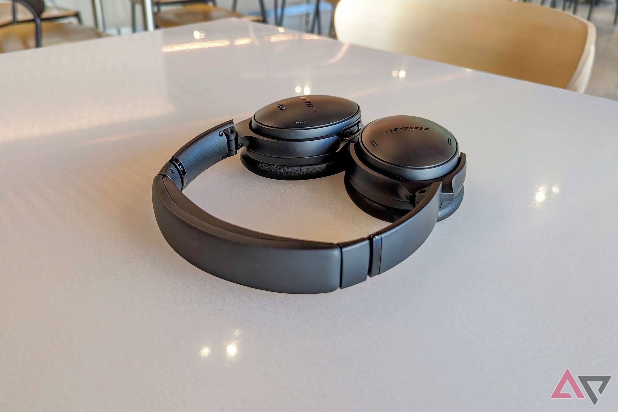 A black pair of Bose QuietComfort Headphones sitting flat on a white table in Connections Cafe