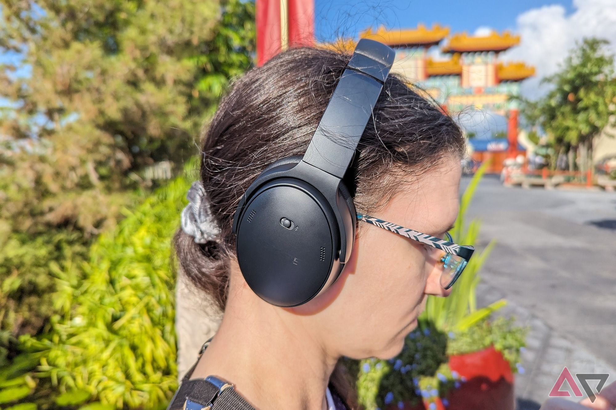 A frizzy-haired Ara Wagoner wearing the Bose QuietComfort Headphones in an empty China pavilion at Epcot 