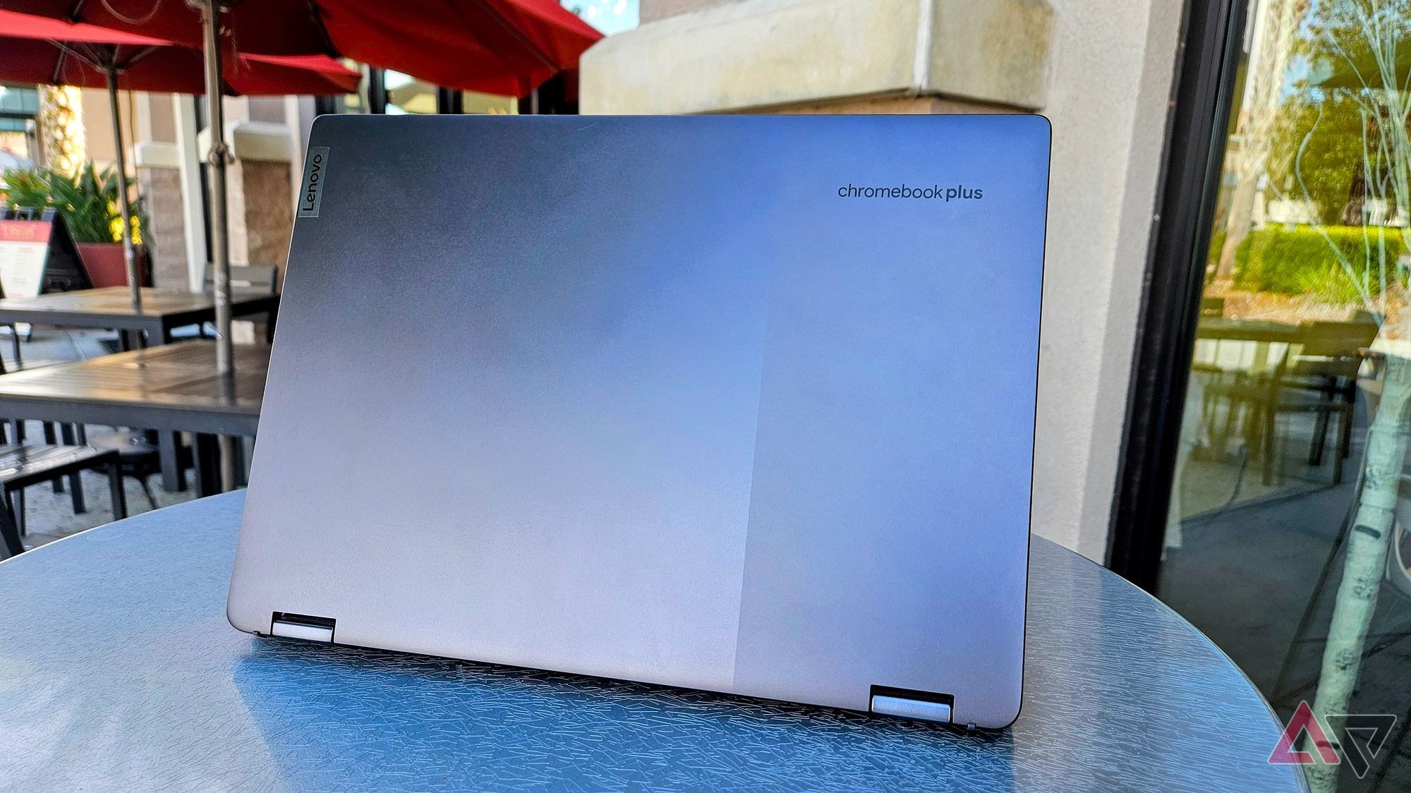 The Lenovo Chromebook Plus Flex 5i open and facing away on an cafe table