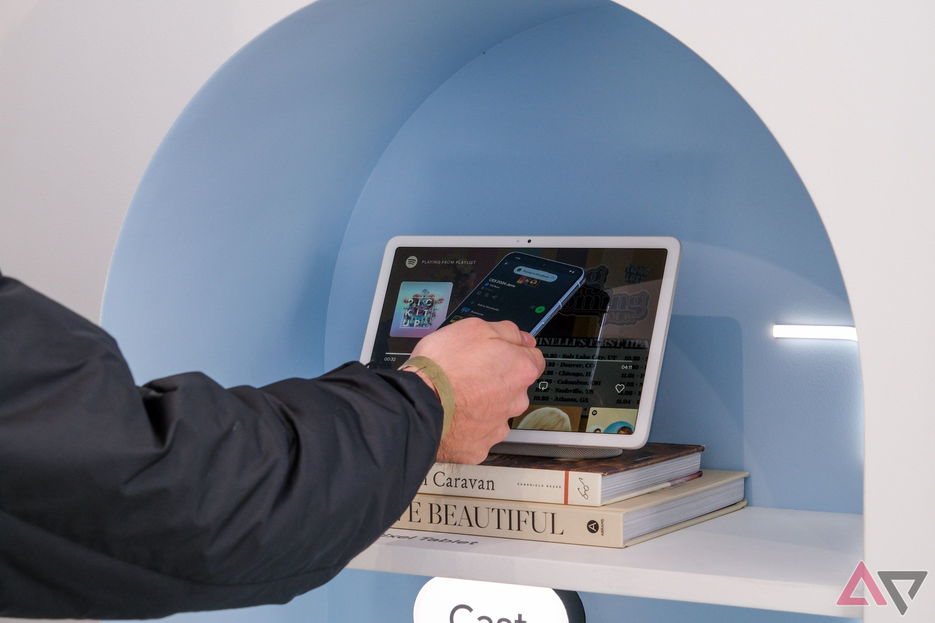 A smartphone held close to a tablet on a charging stand