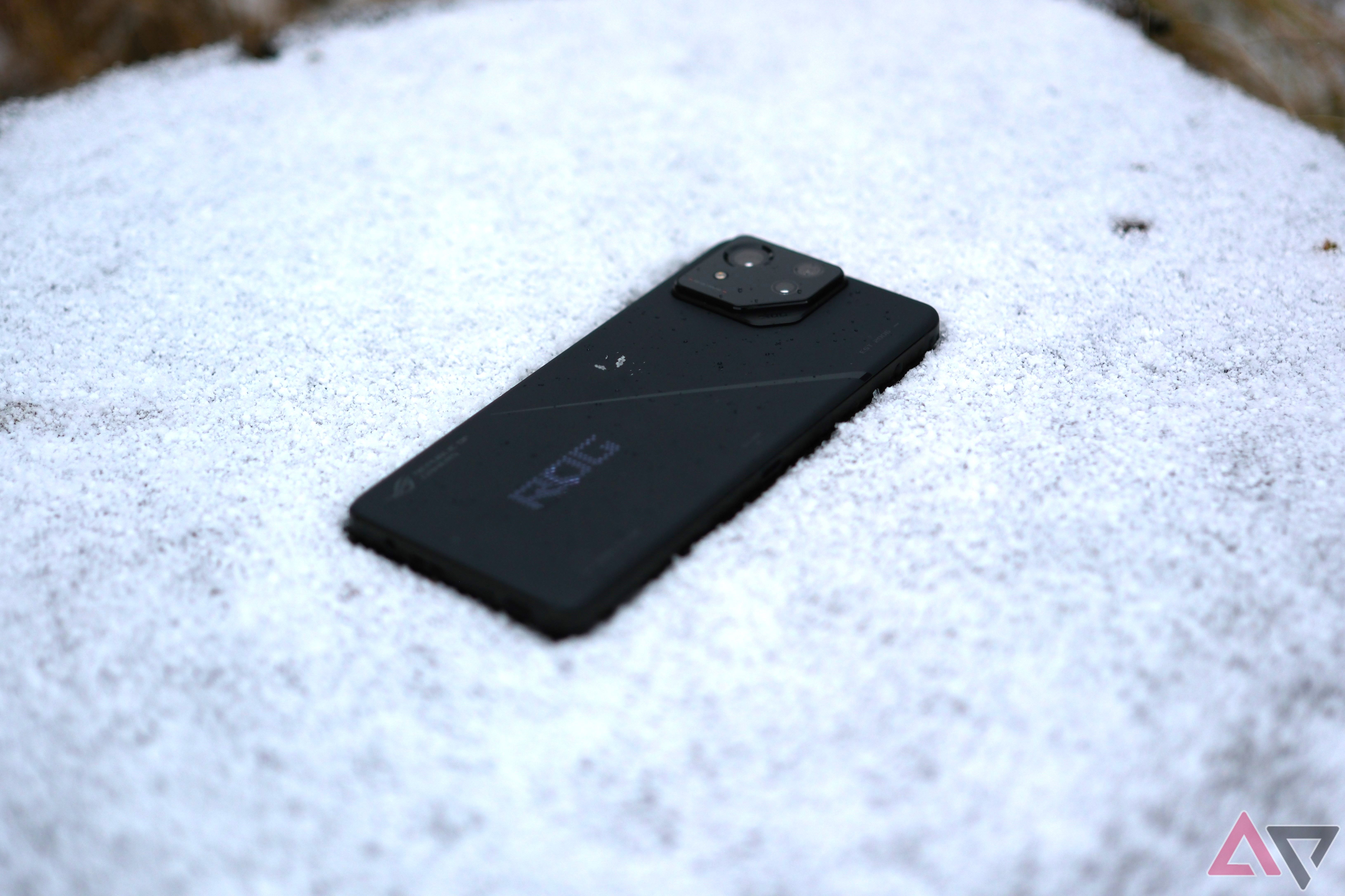 ROG Phone 8 Pro laying in snow with rog logo shoing in white leds