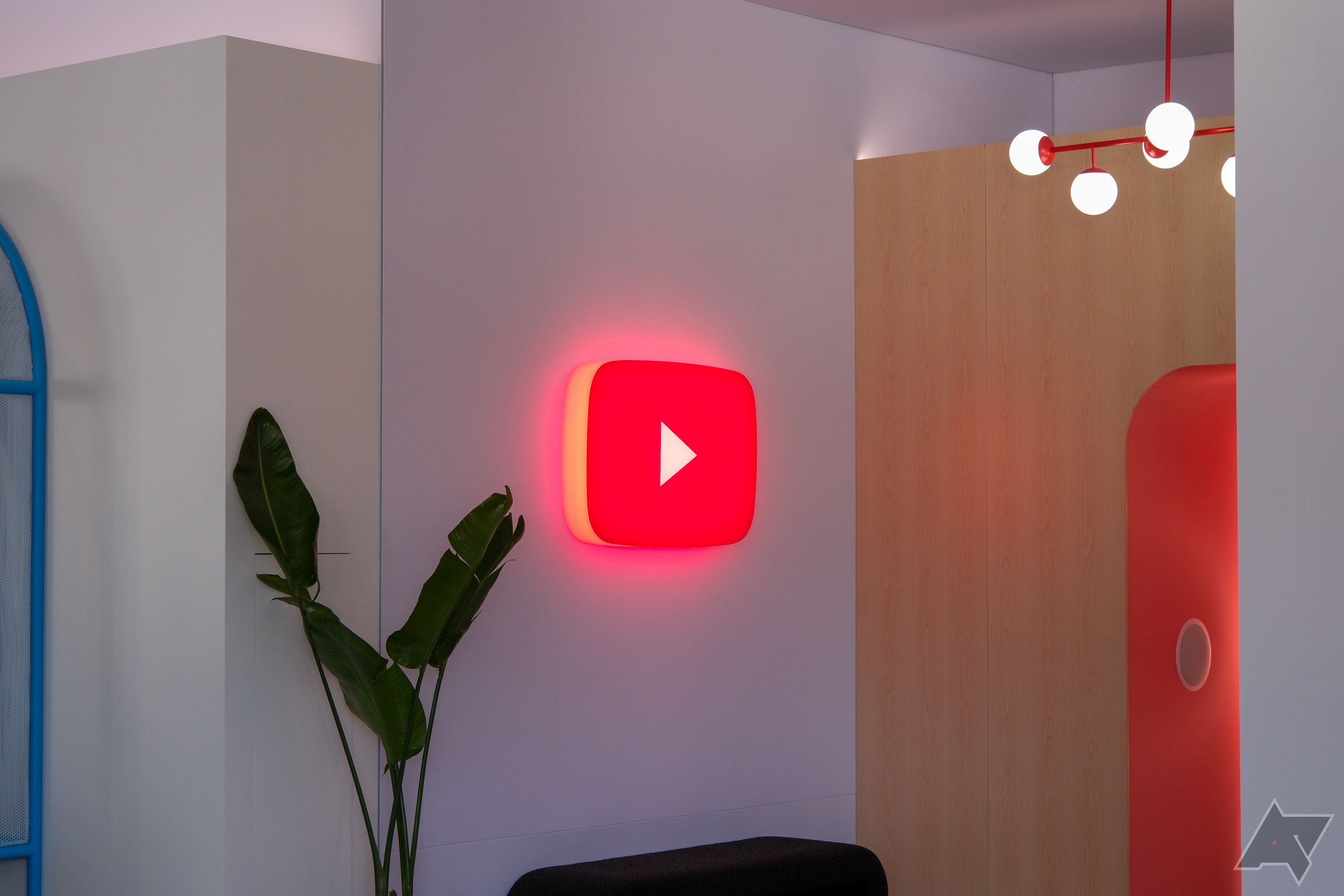 A glowing YouTube icon mounted on a wall