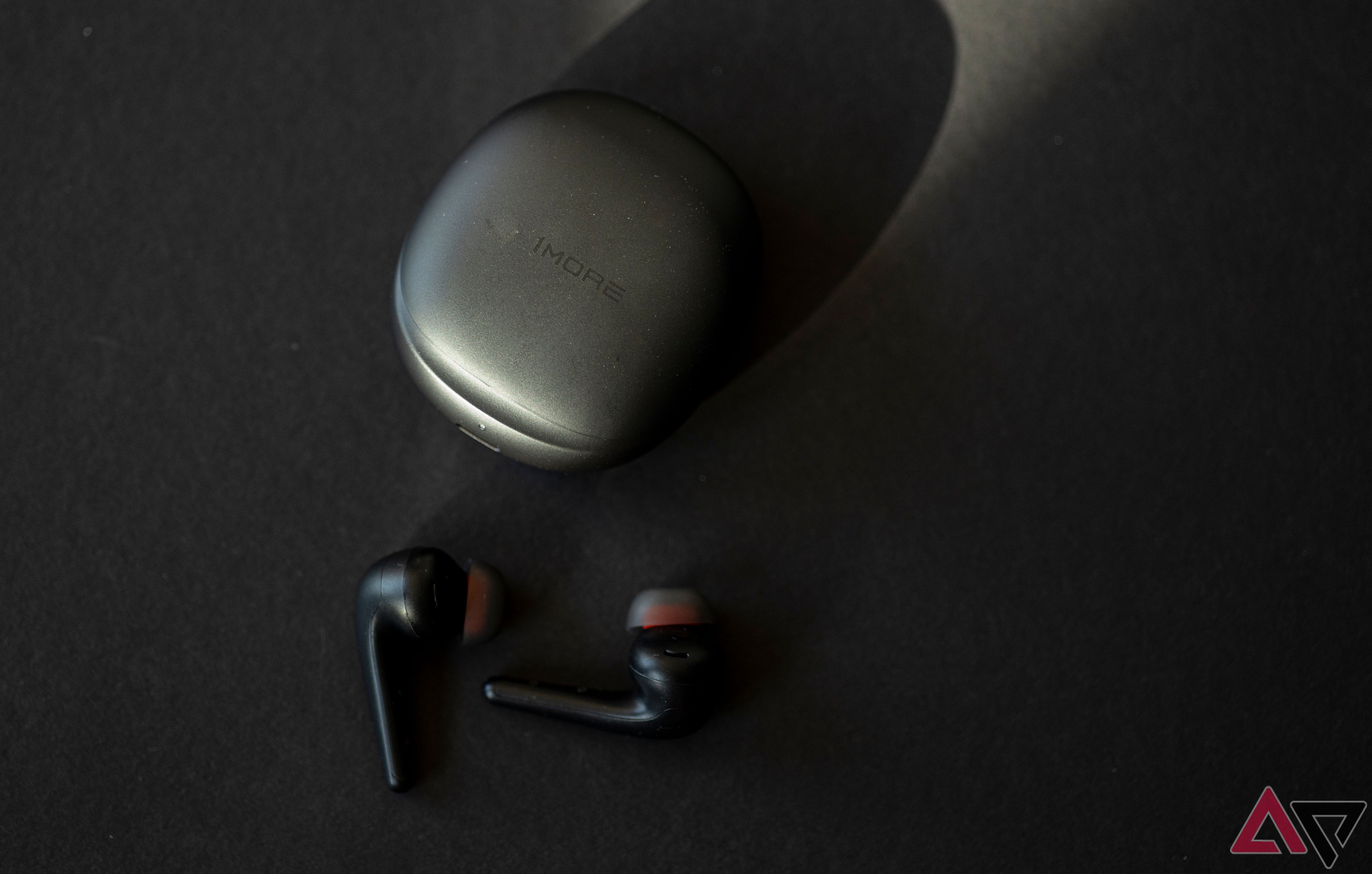 1More Aero earbuds on black background next to closed case