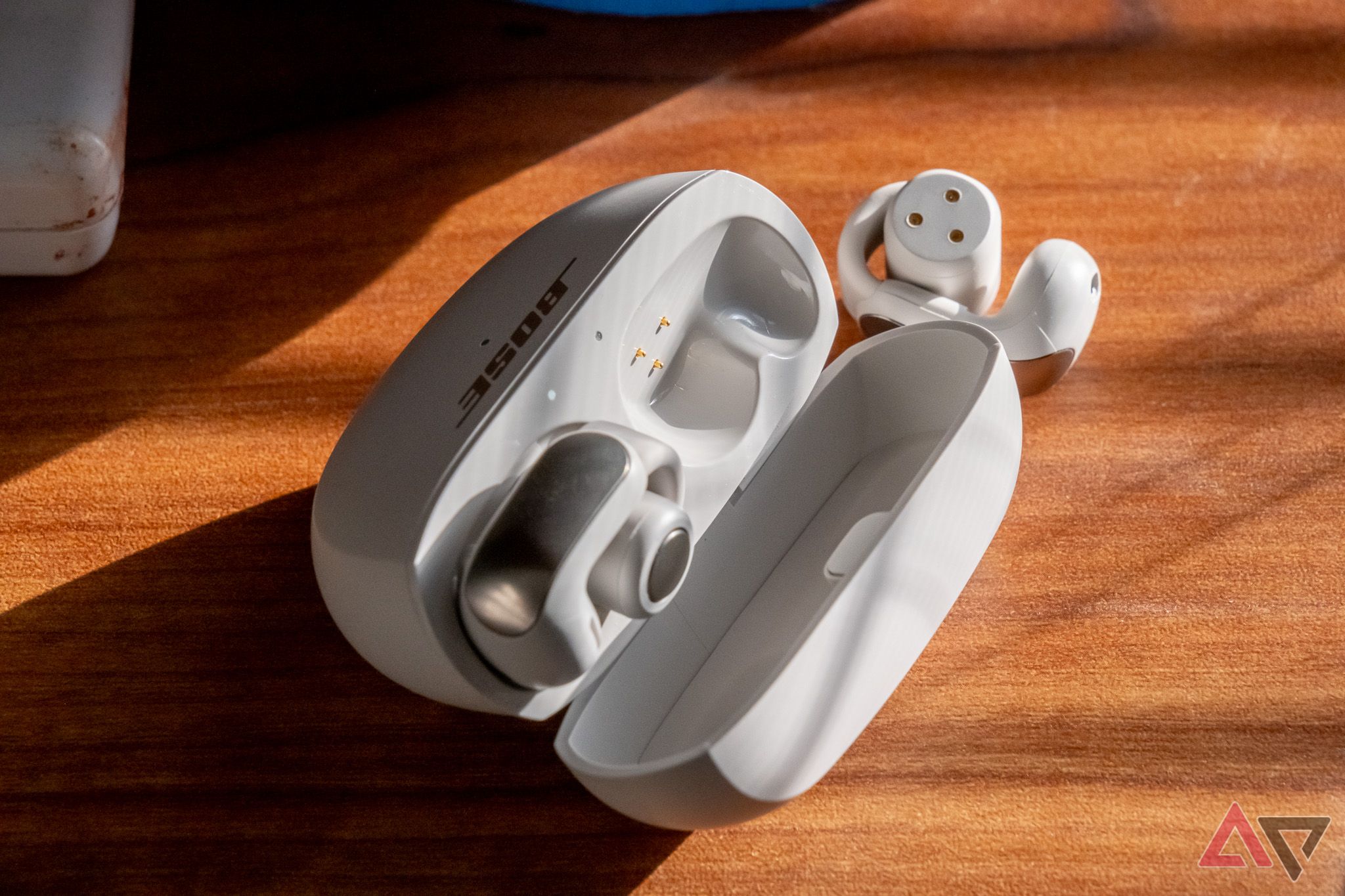 The Bose Ultra Open Earbuds with their case, showing magnetic charging pins