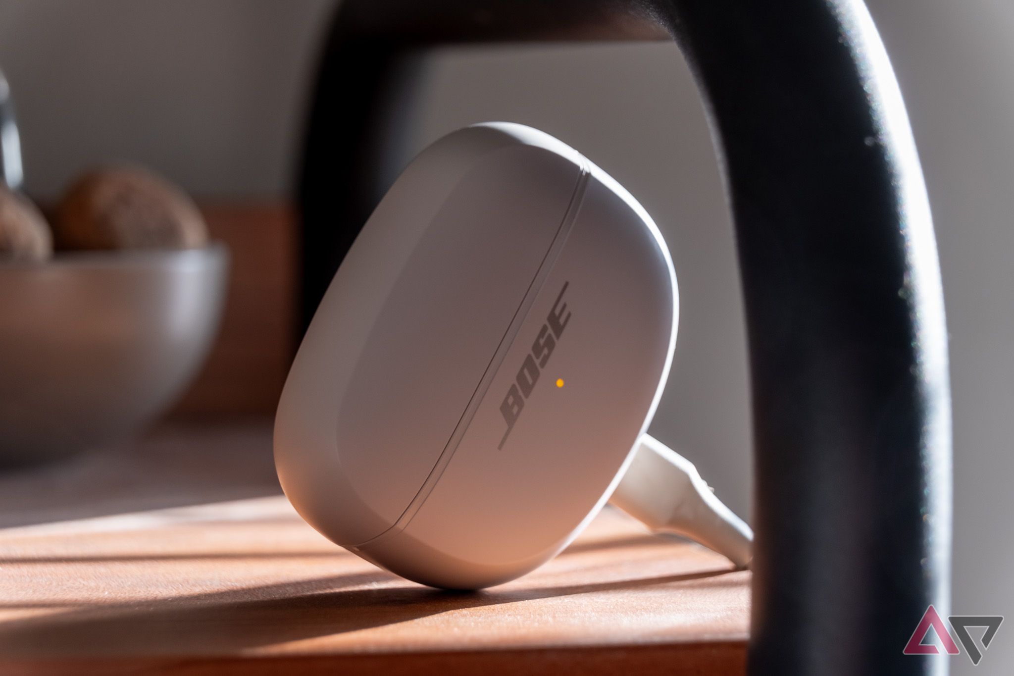 The Bose Ultra Open Earbuds charging case, plugged in and charging