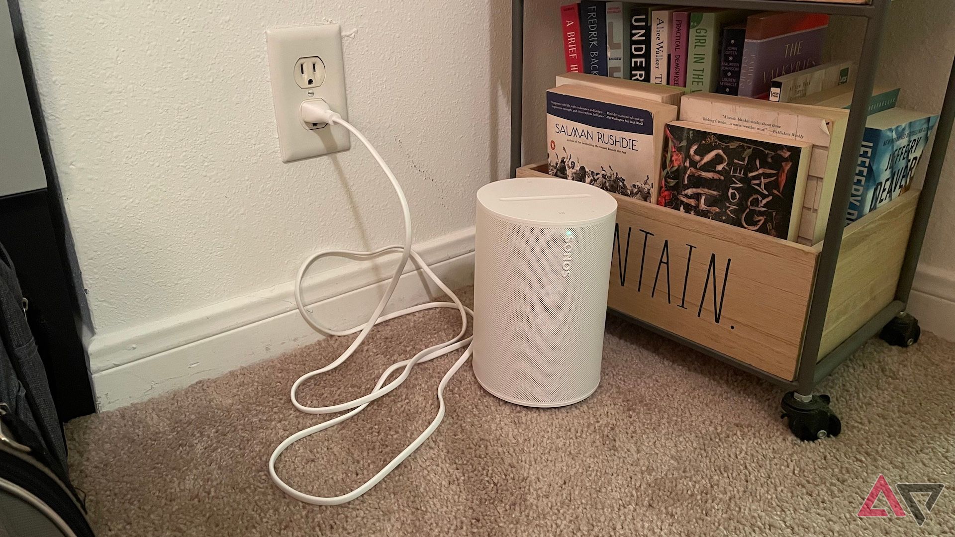 The Sonos Era 100 plugged into a wall outlet