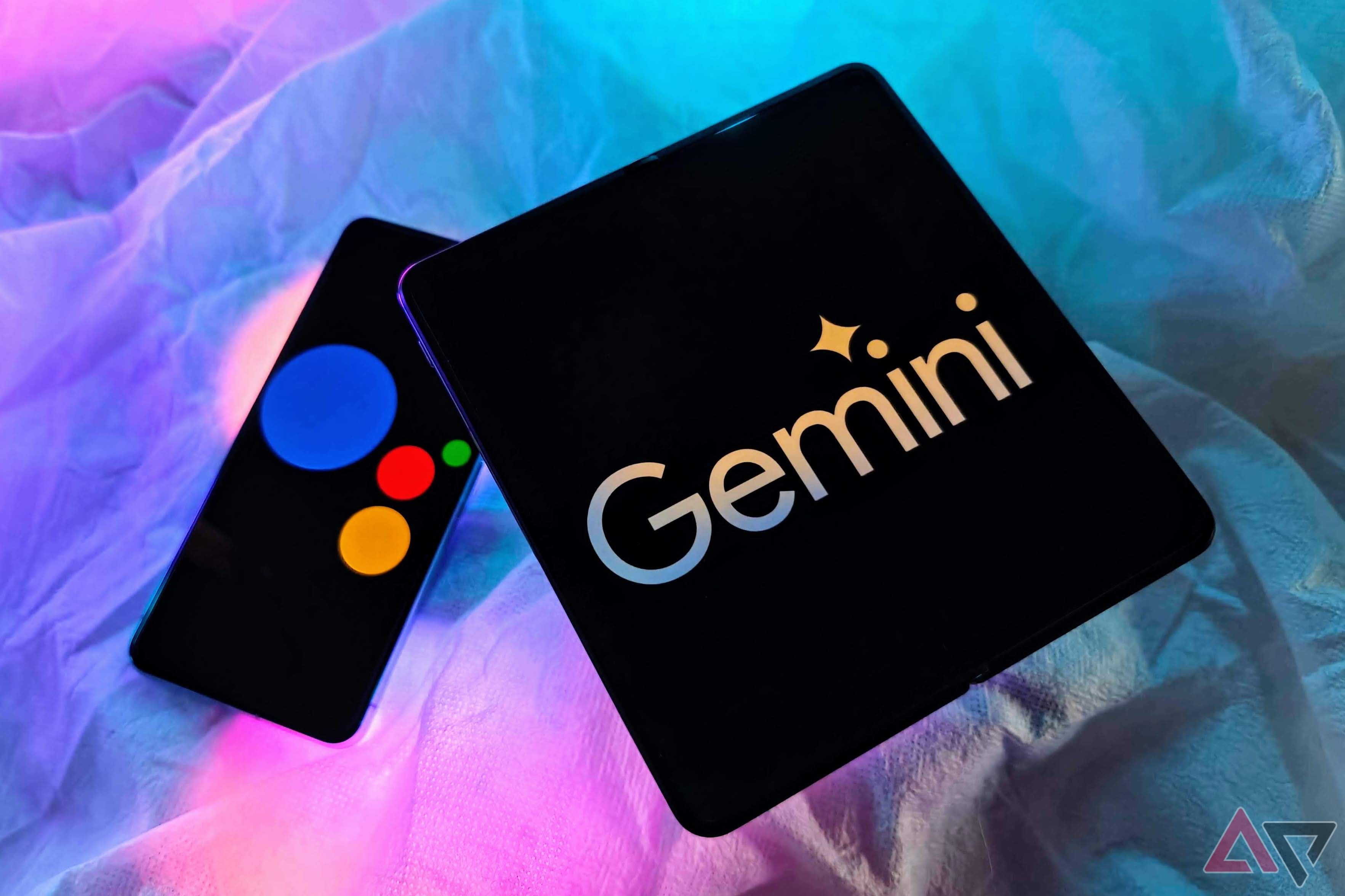 OnePlus Open with Google Gemini logo and Pixel 8 Pro with Google Assistant logo on a table with RGB lights