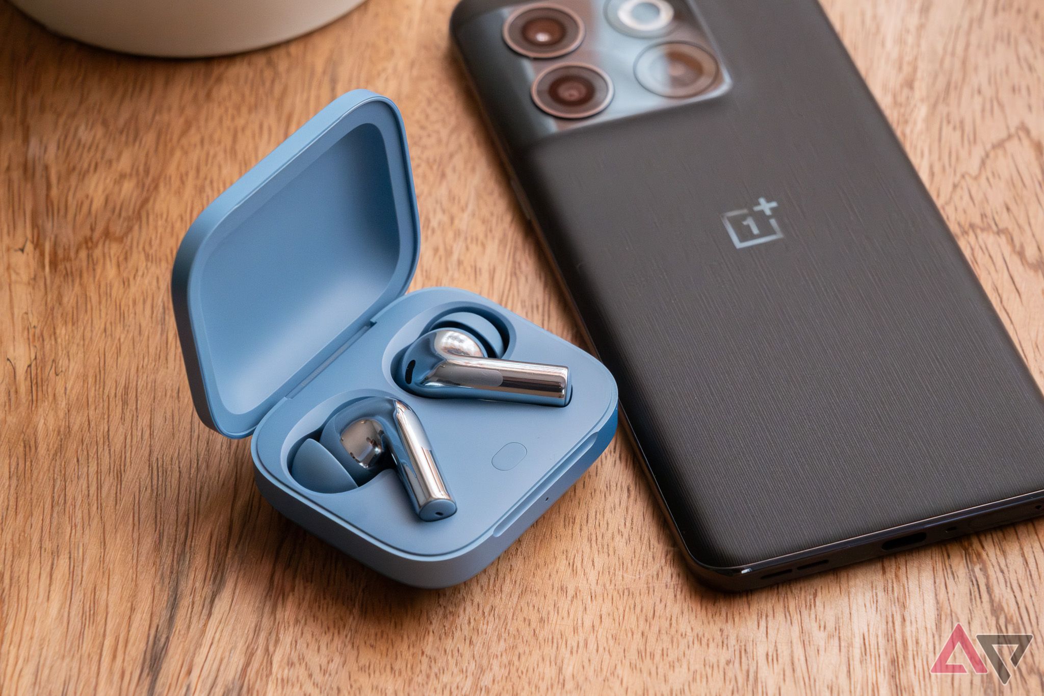 True wireless earbuds next to a OnePlus smartphone