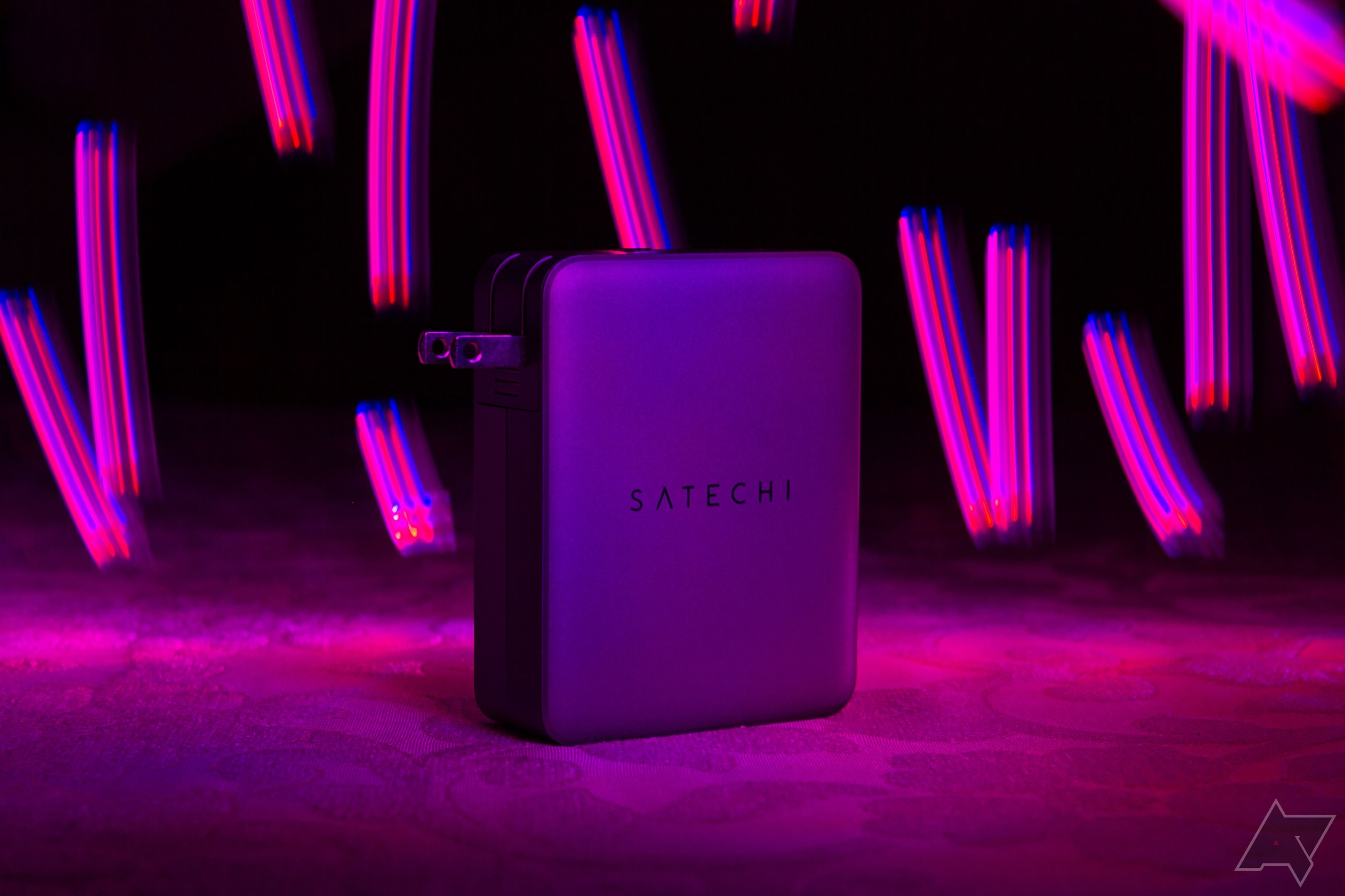 The Satechi 145W GaN travel charger with swirling purple lights in the background