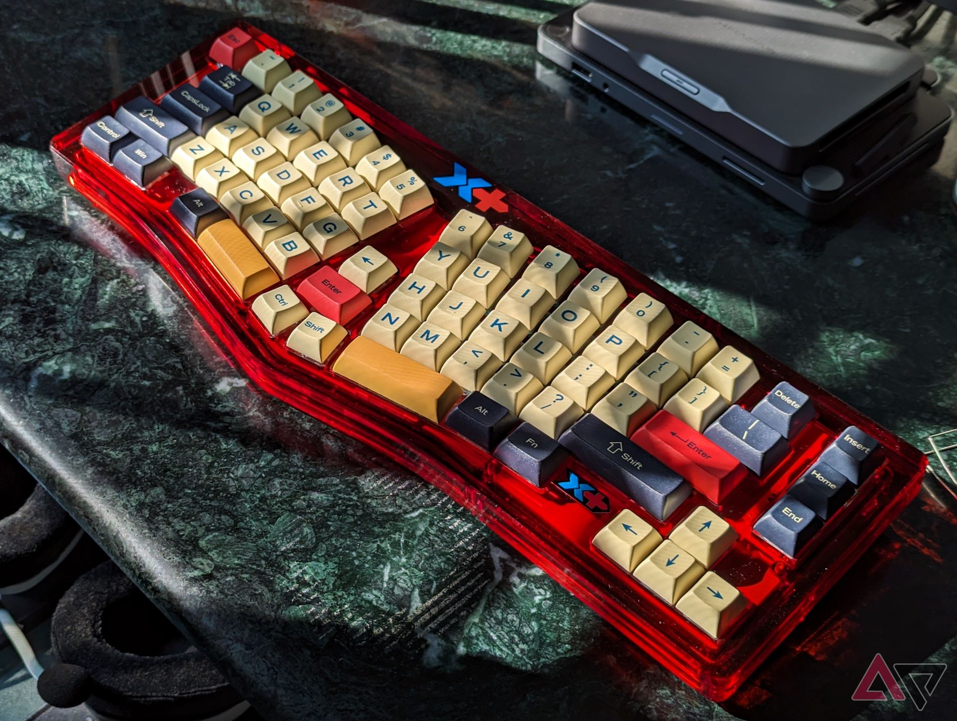 Red split mechanical keyboard with peach keycaps on a green marble desk