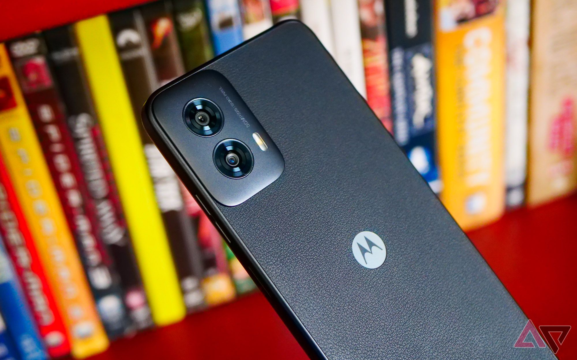 The Moto G Power (2024) held face down next to DVDs.