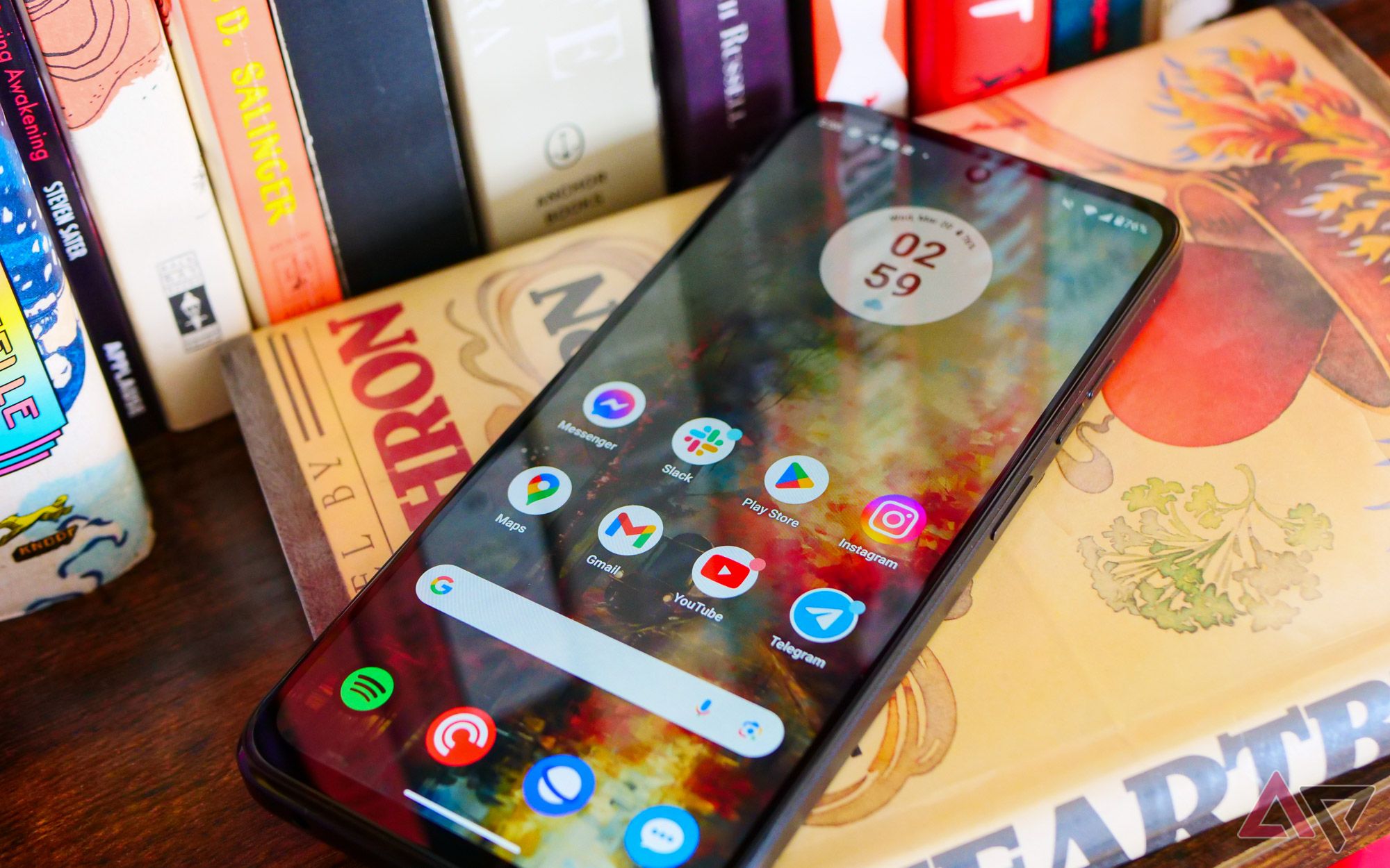 The Moto G Power (2024) lying face up on a bookcase with the display on.