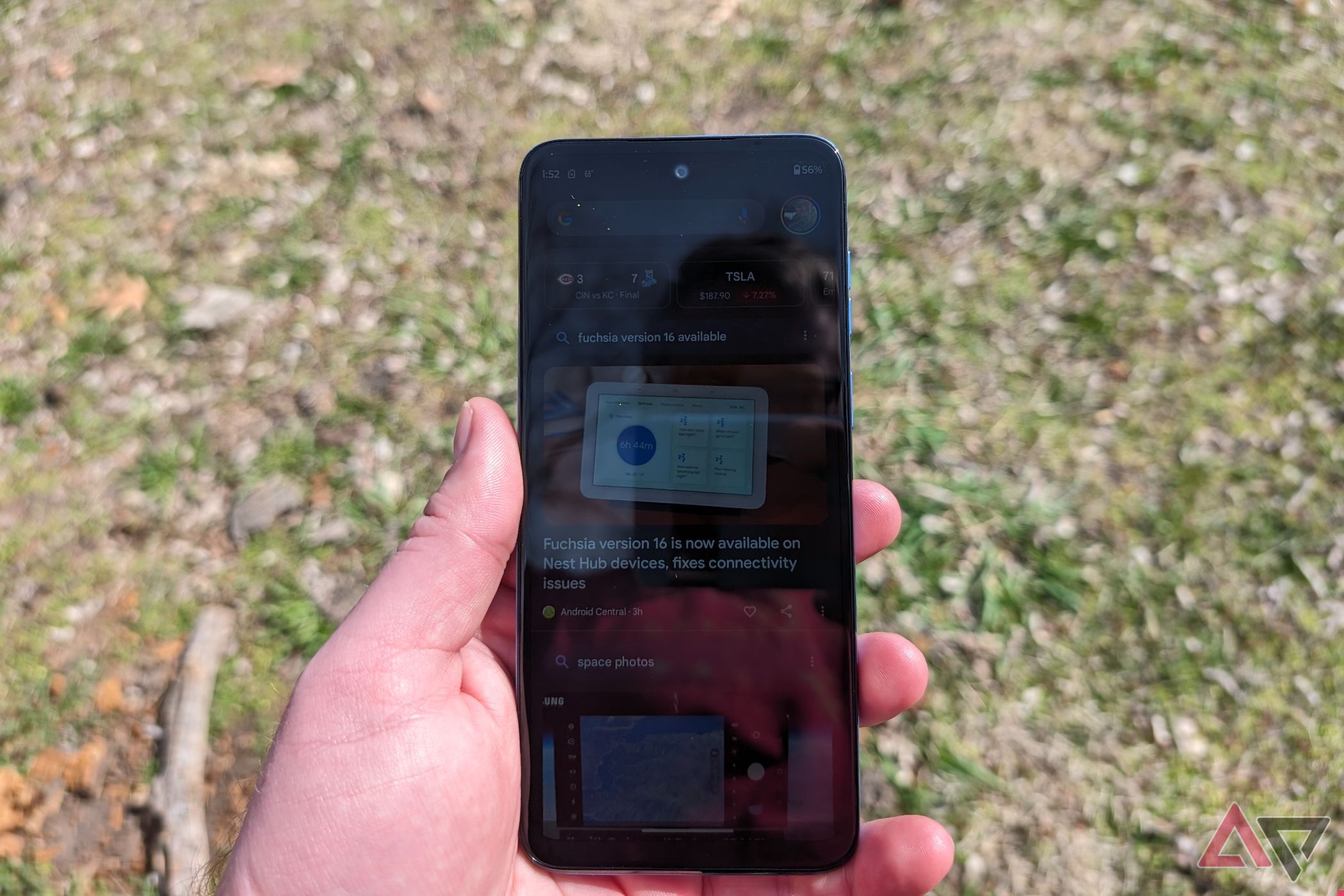 A person holds a Moto G Play in direct sunlight to show a washed out screen.