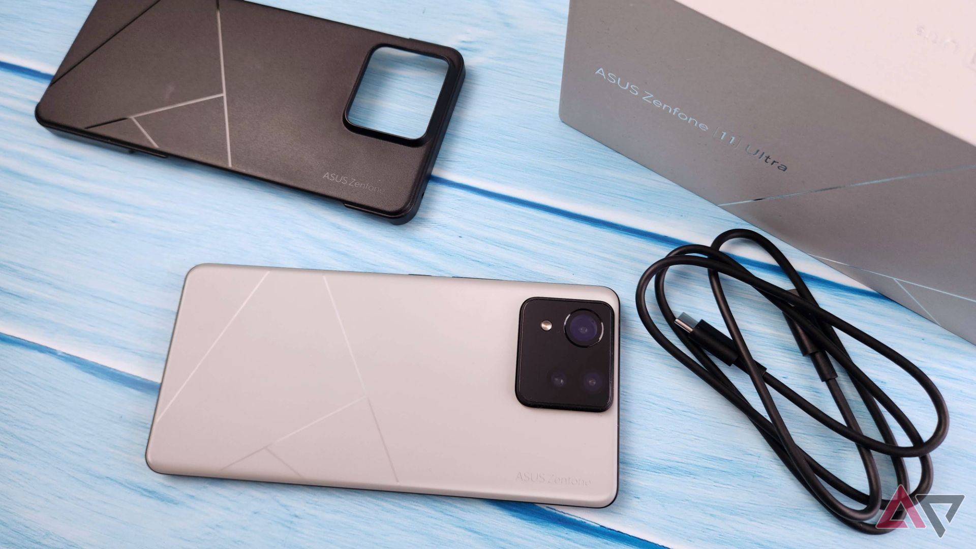 Asus Zenfone 11 Ultra next to a black phone case, a USB-C cable, and a box